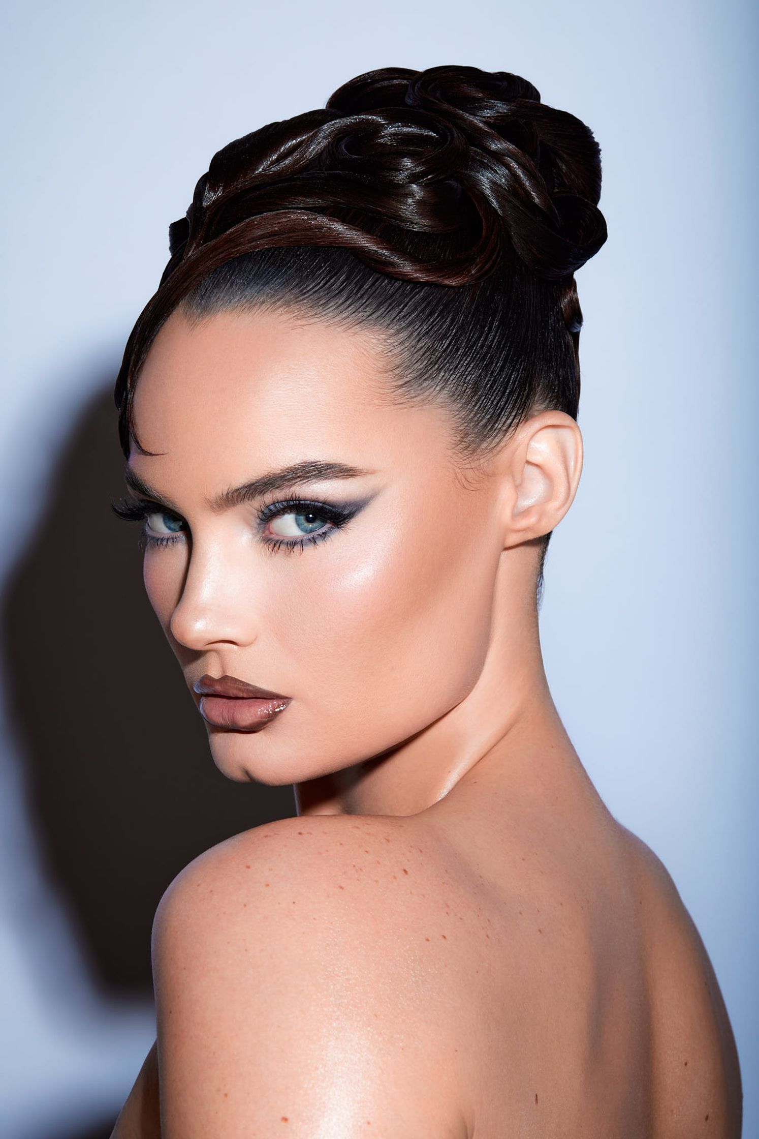 a woman in a black dress with a braided updo