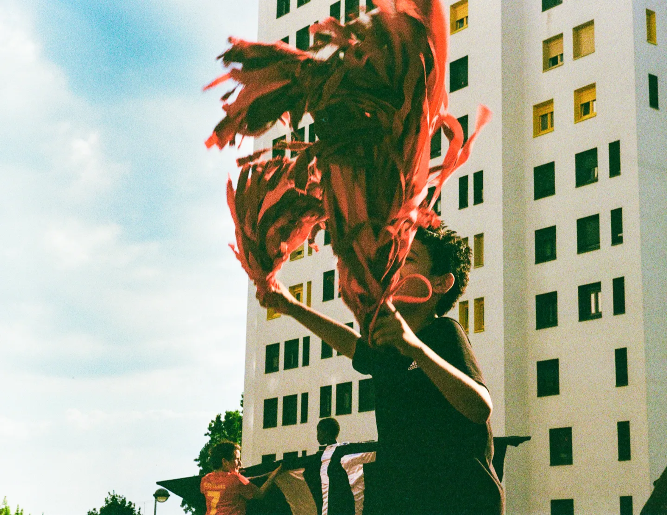 a boy is flying a kite in front of a building