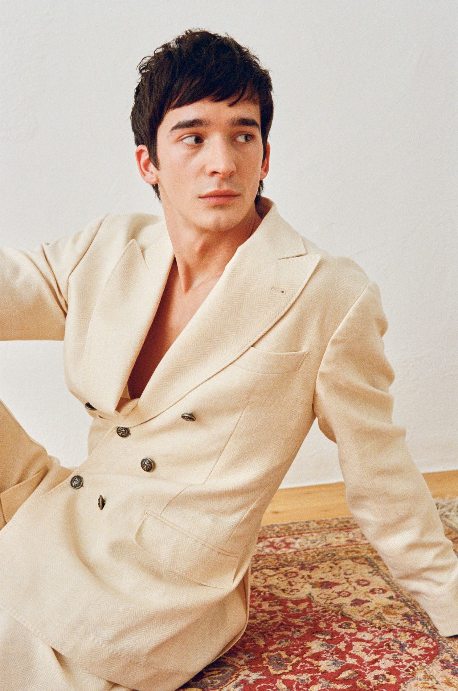 a man in a suit sitting on a rug