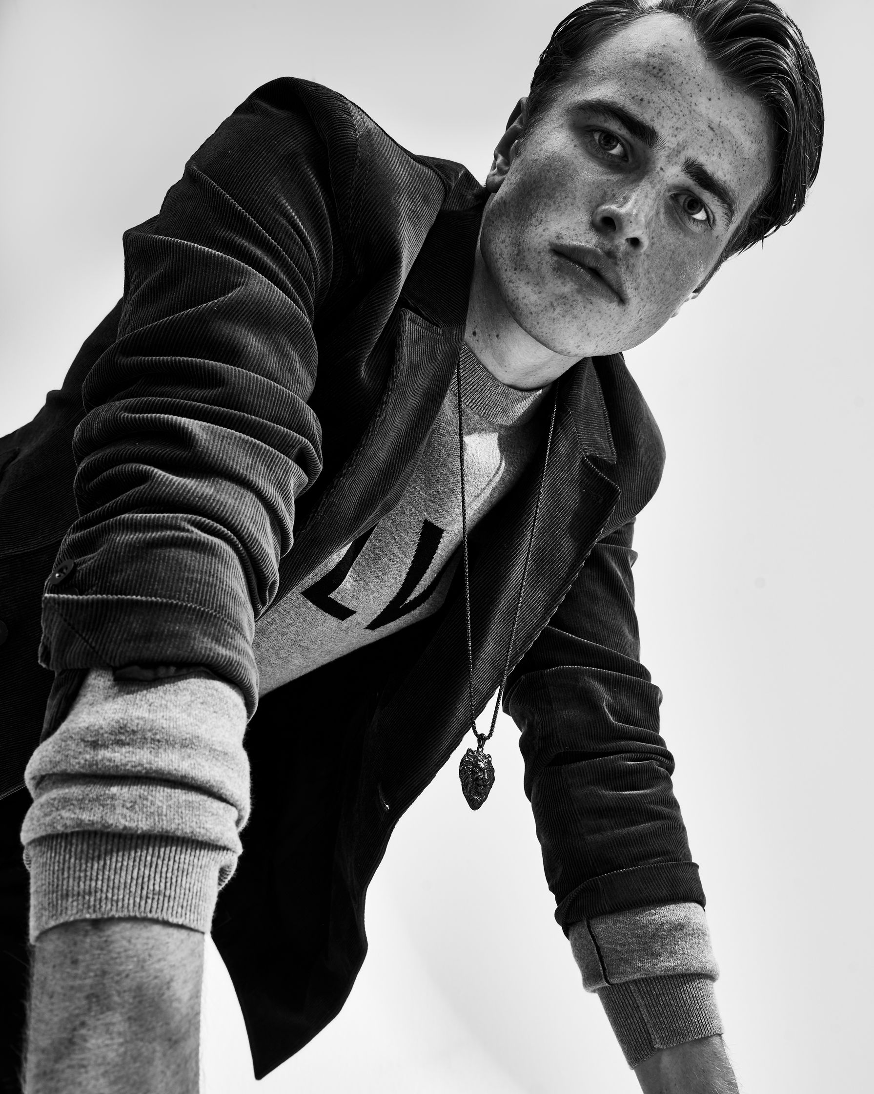 a black and white photo of a man leaning on a skateboard