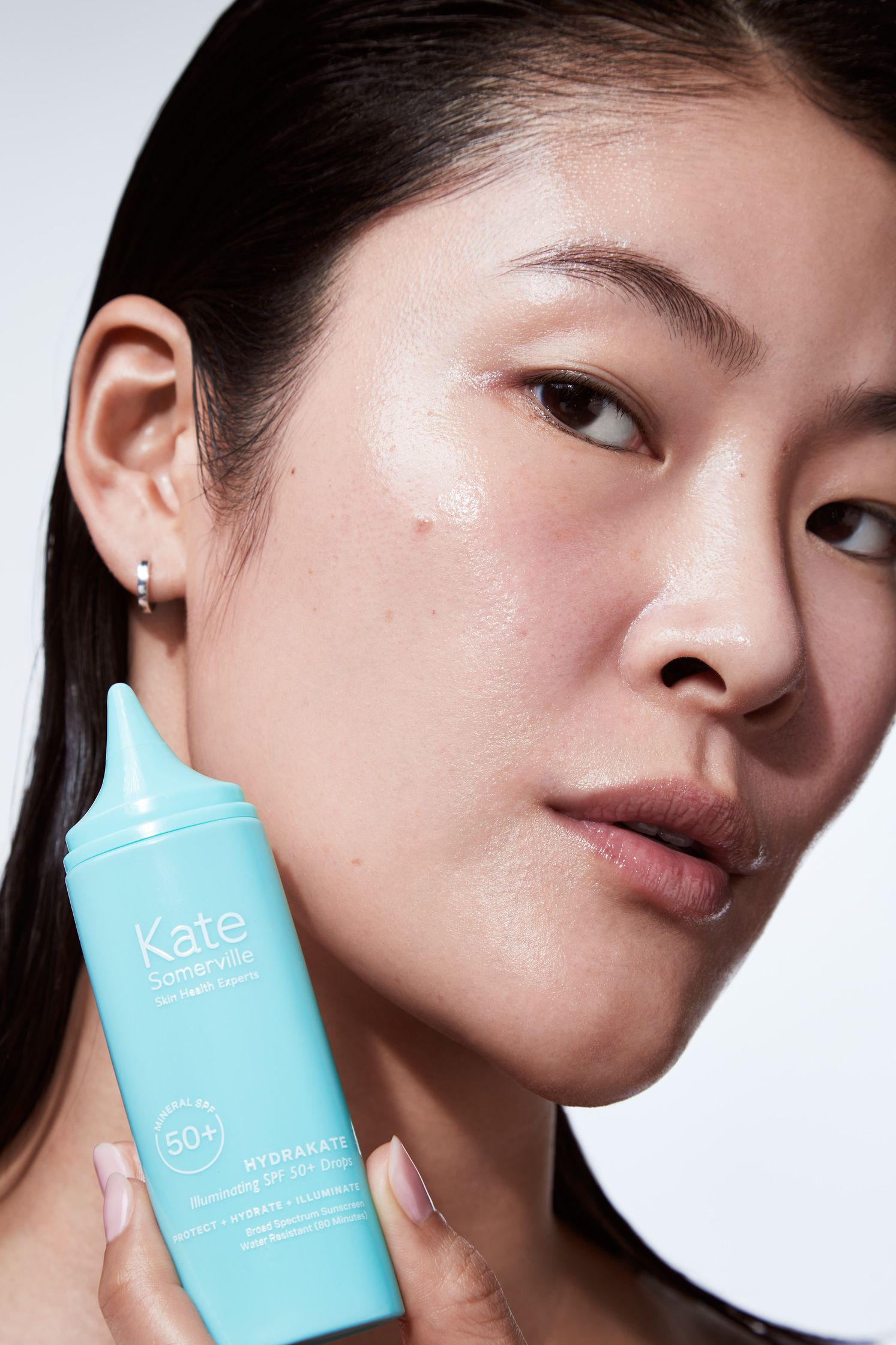 a woman holding a bottle of sunscreen