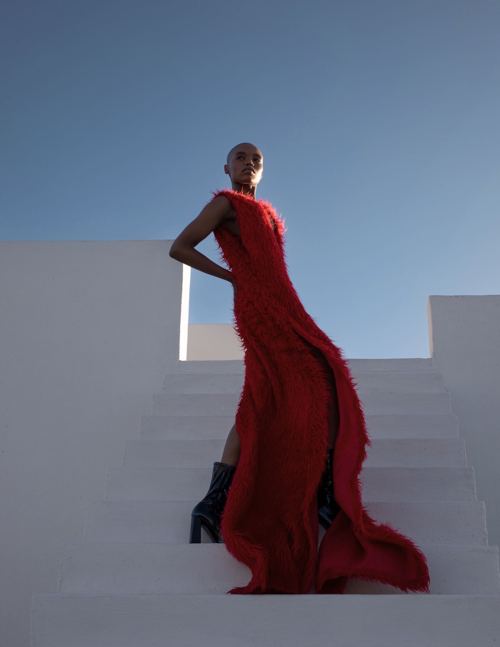 a woman in a red dress standing on steps