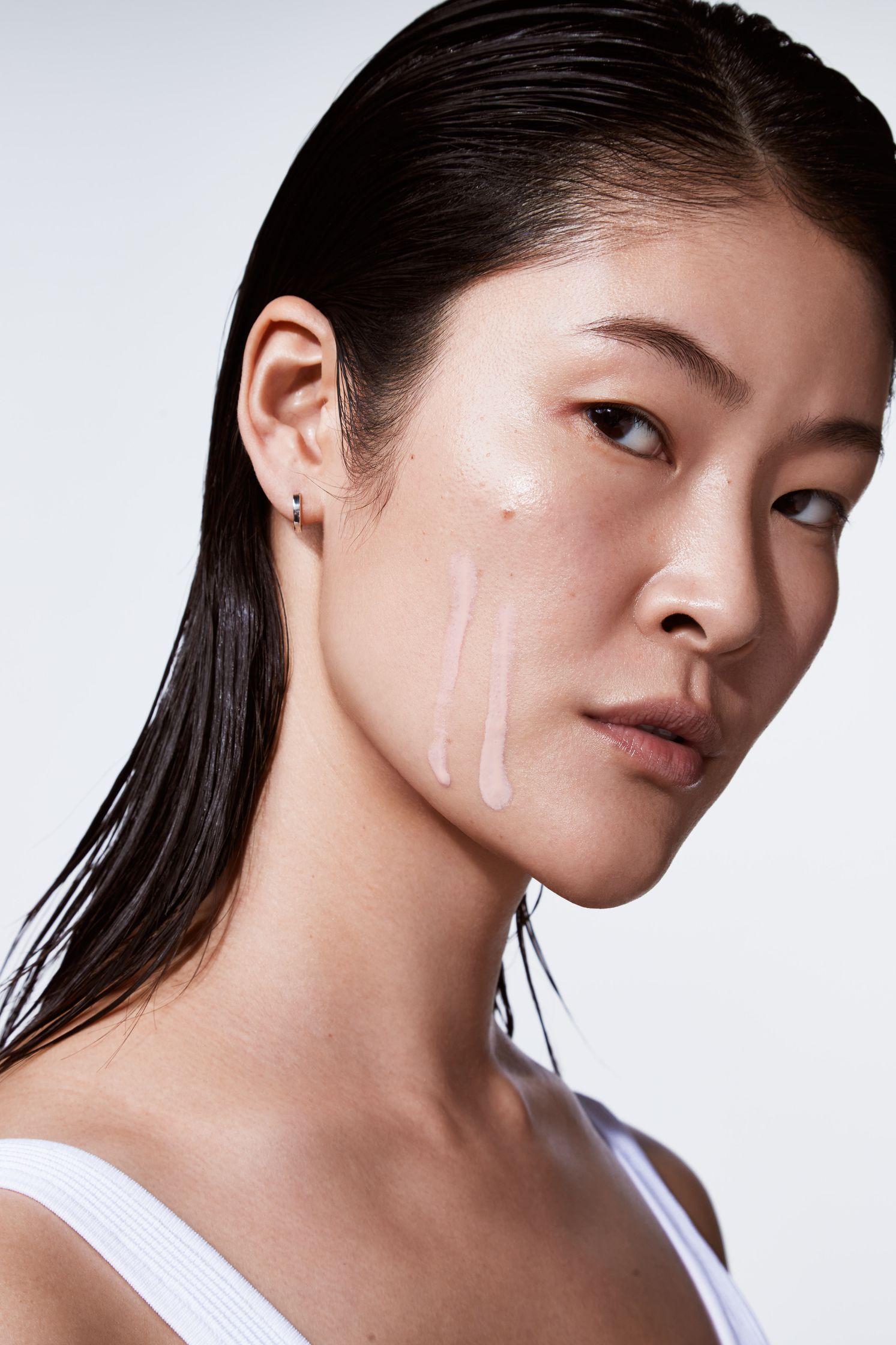 an asian woman with a white shirt and makeup on her face
