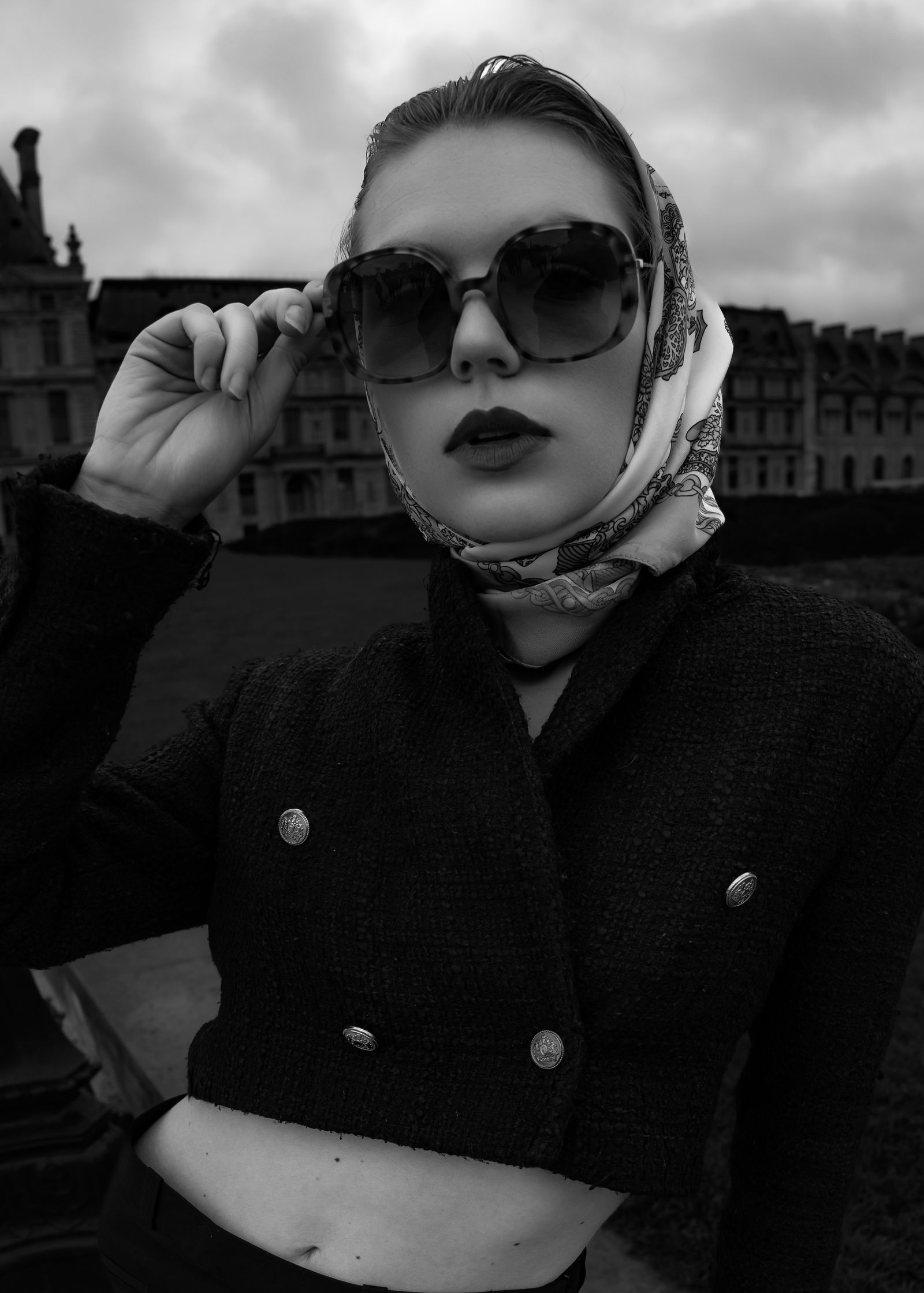 a black and white photo of a woman wearing a scarf and sunglasses