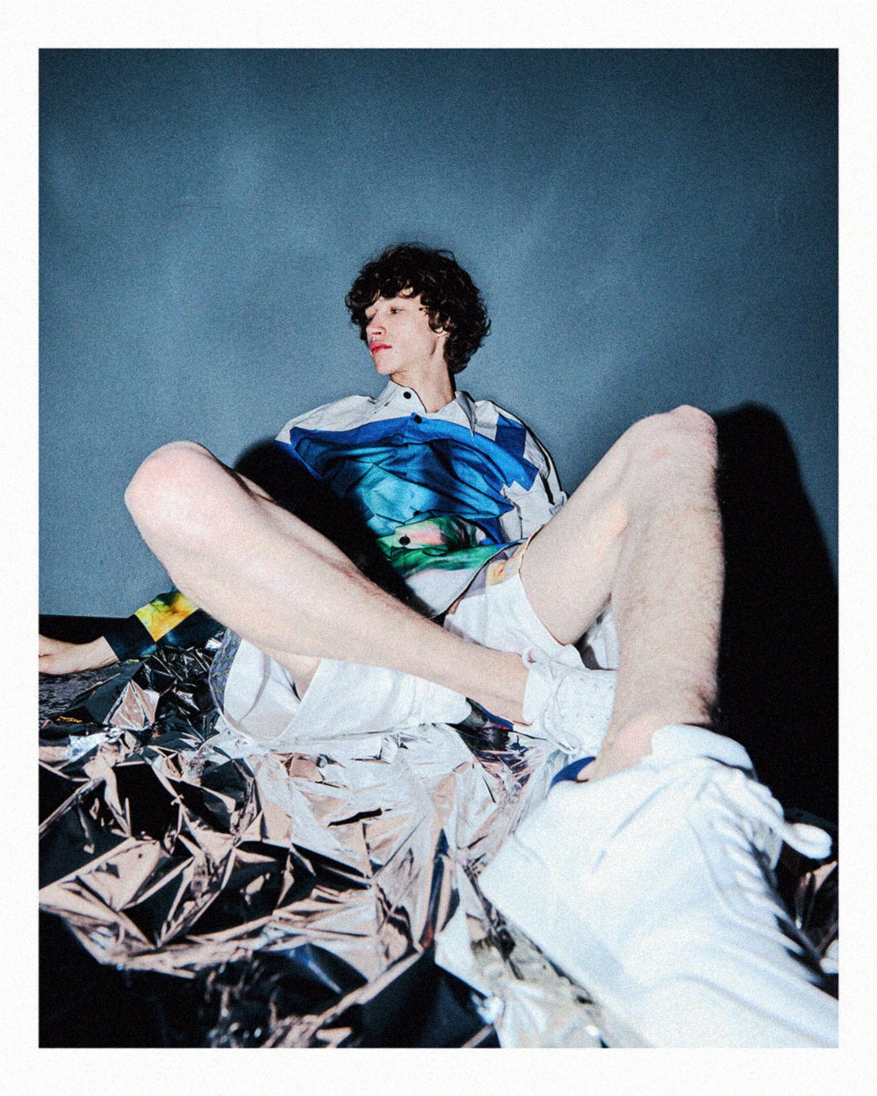 a man sitting on top of a piece of cloth