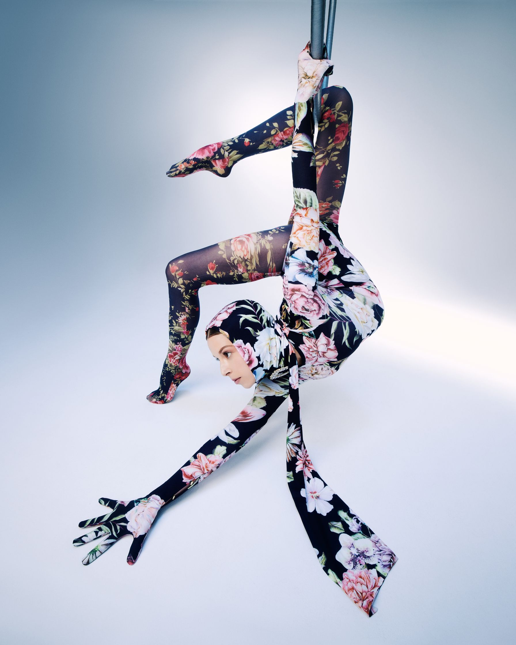 a woman in a floral outfit doing a pole dance