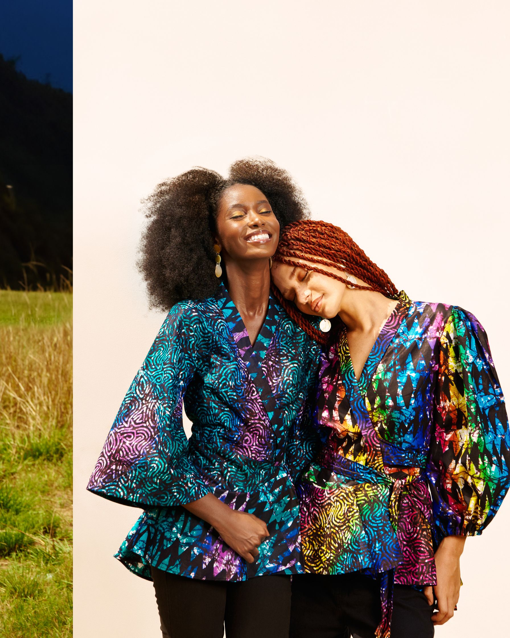 two women are posing for a photo in a field
