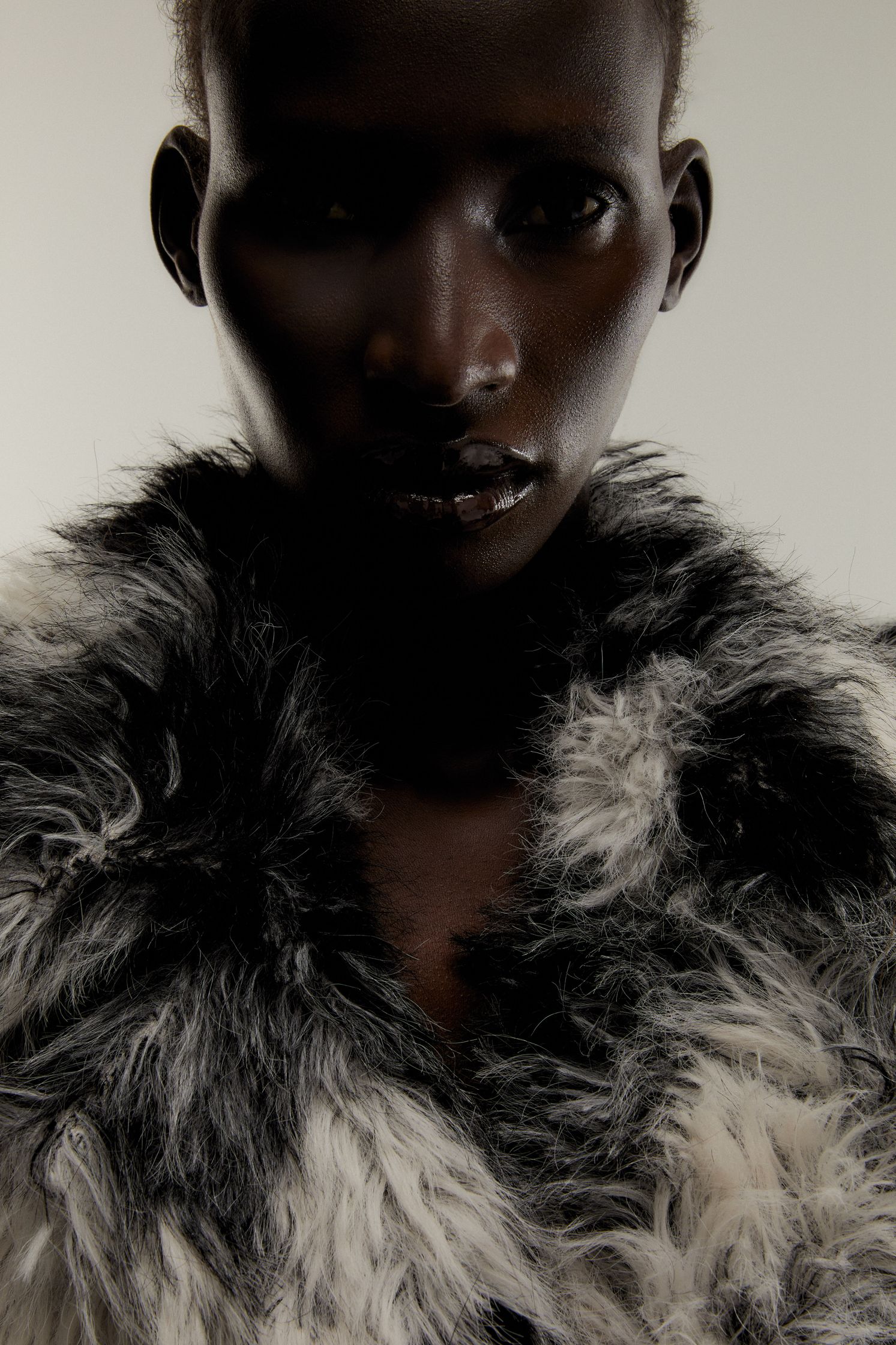 a black and white woman in a fur coat