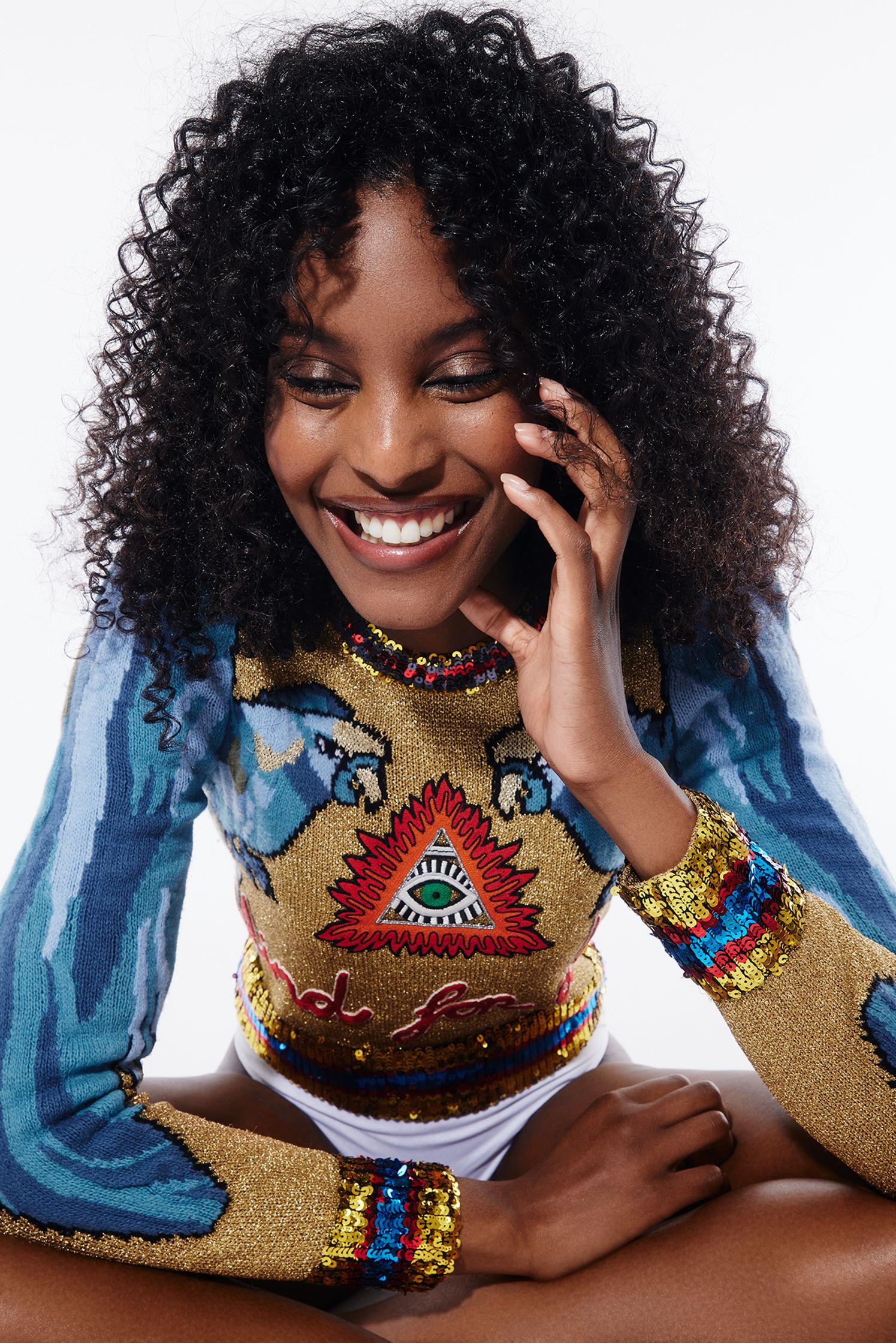 a woman with curly hair is smiling while talking on the phone