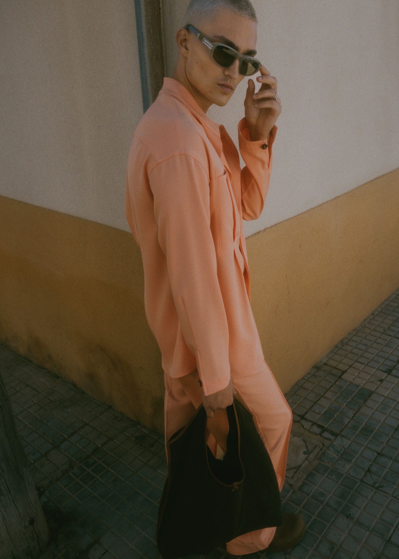 a man in an orange suit and sunglasses is talking on the phone