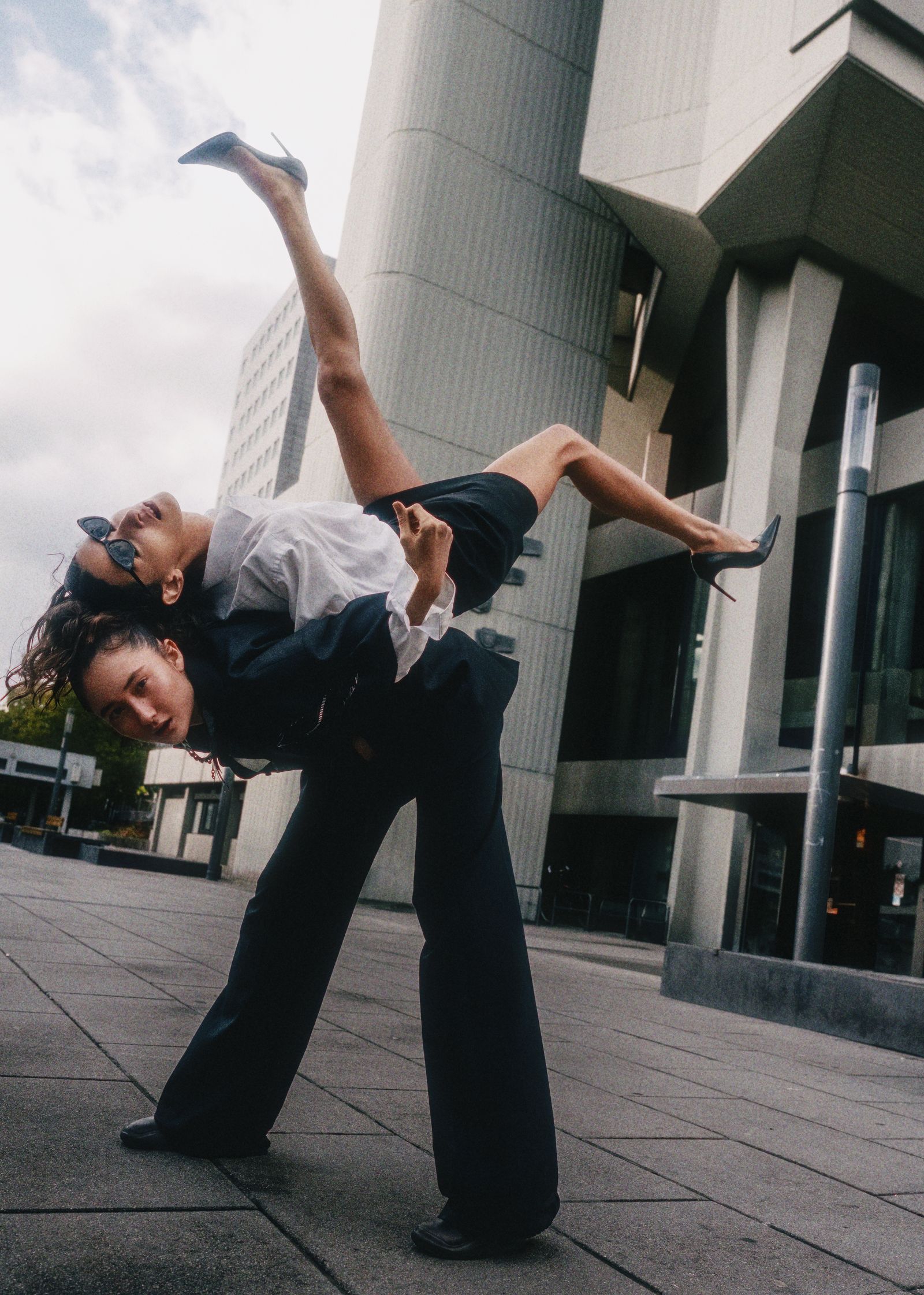 a man and a woman doing a dance in front of a building