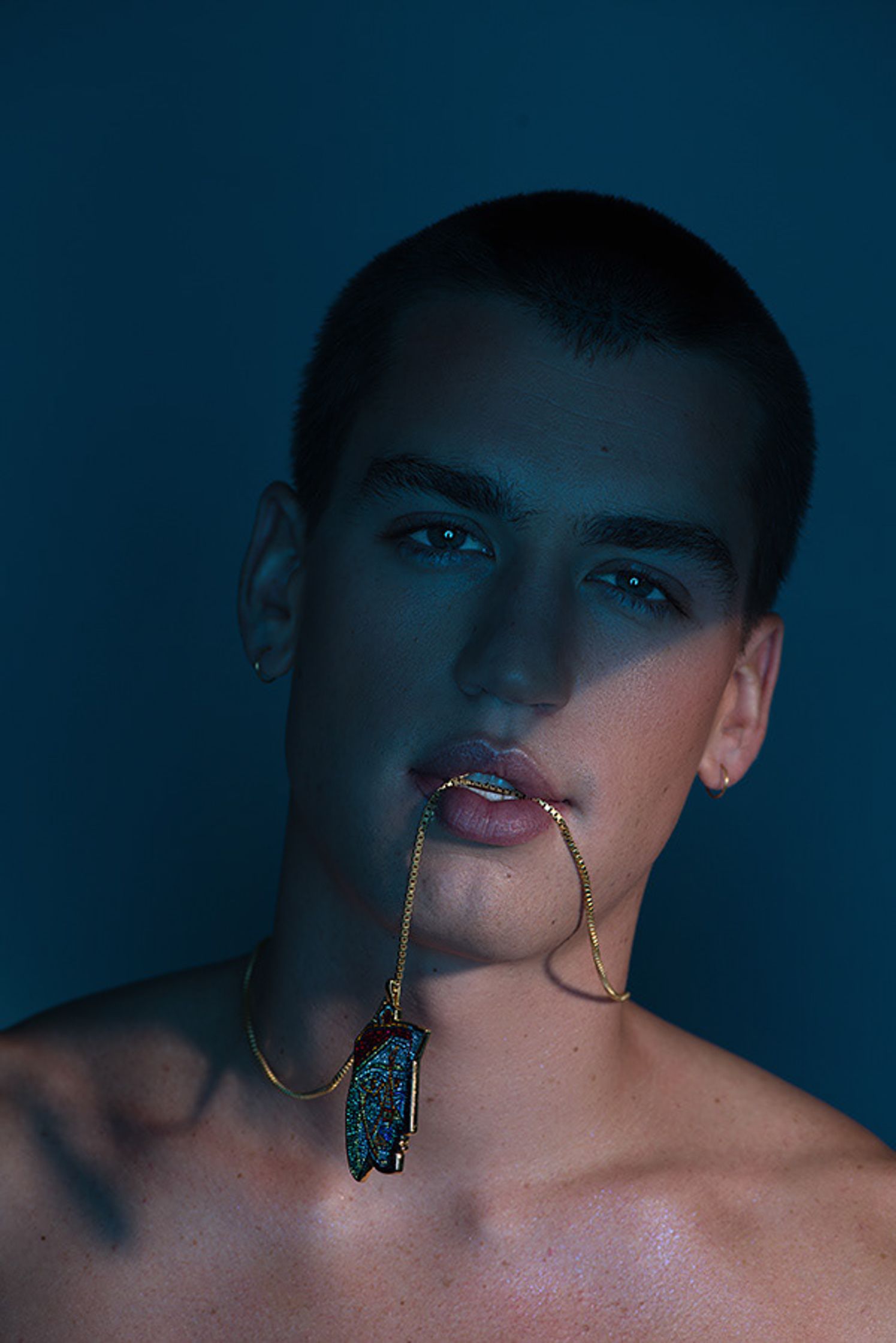 a man with a necklace in his mouth