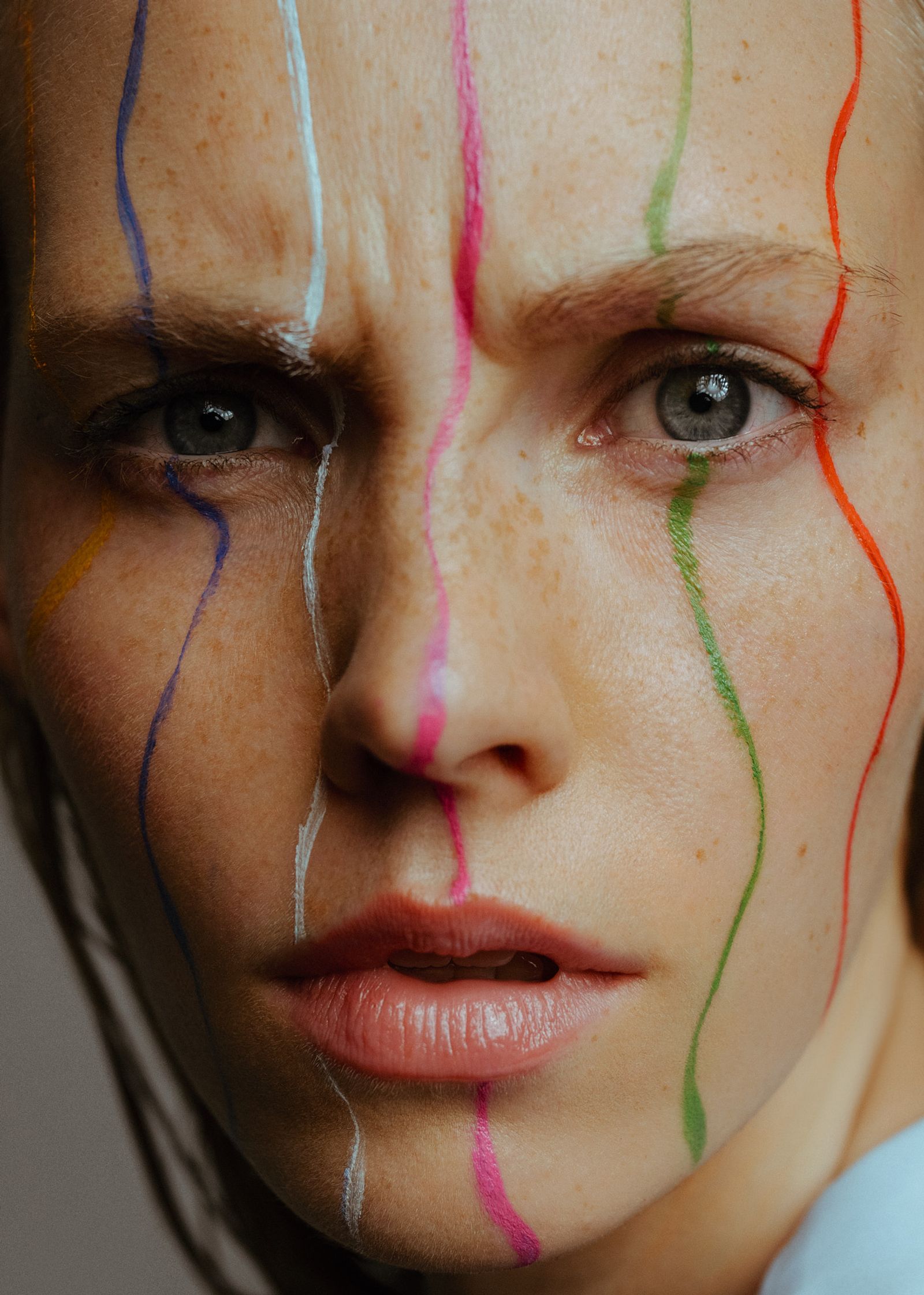 a woman with her face painted with different colors