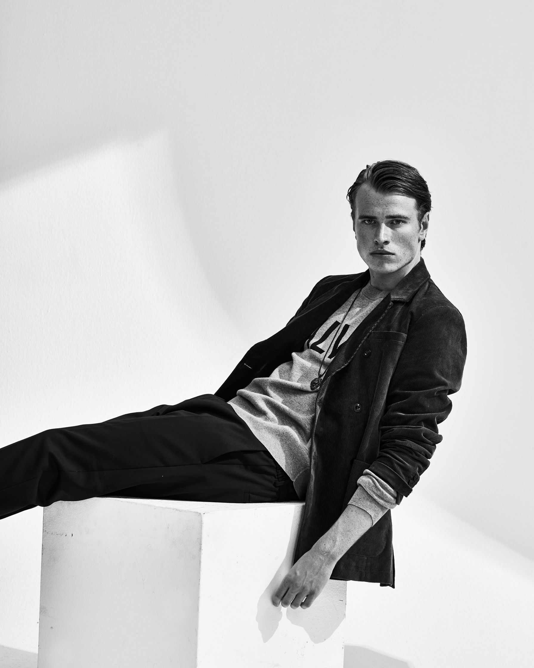 a man posing on a white cube