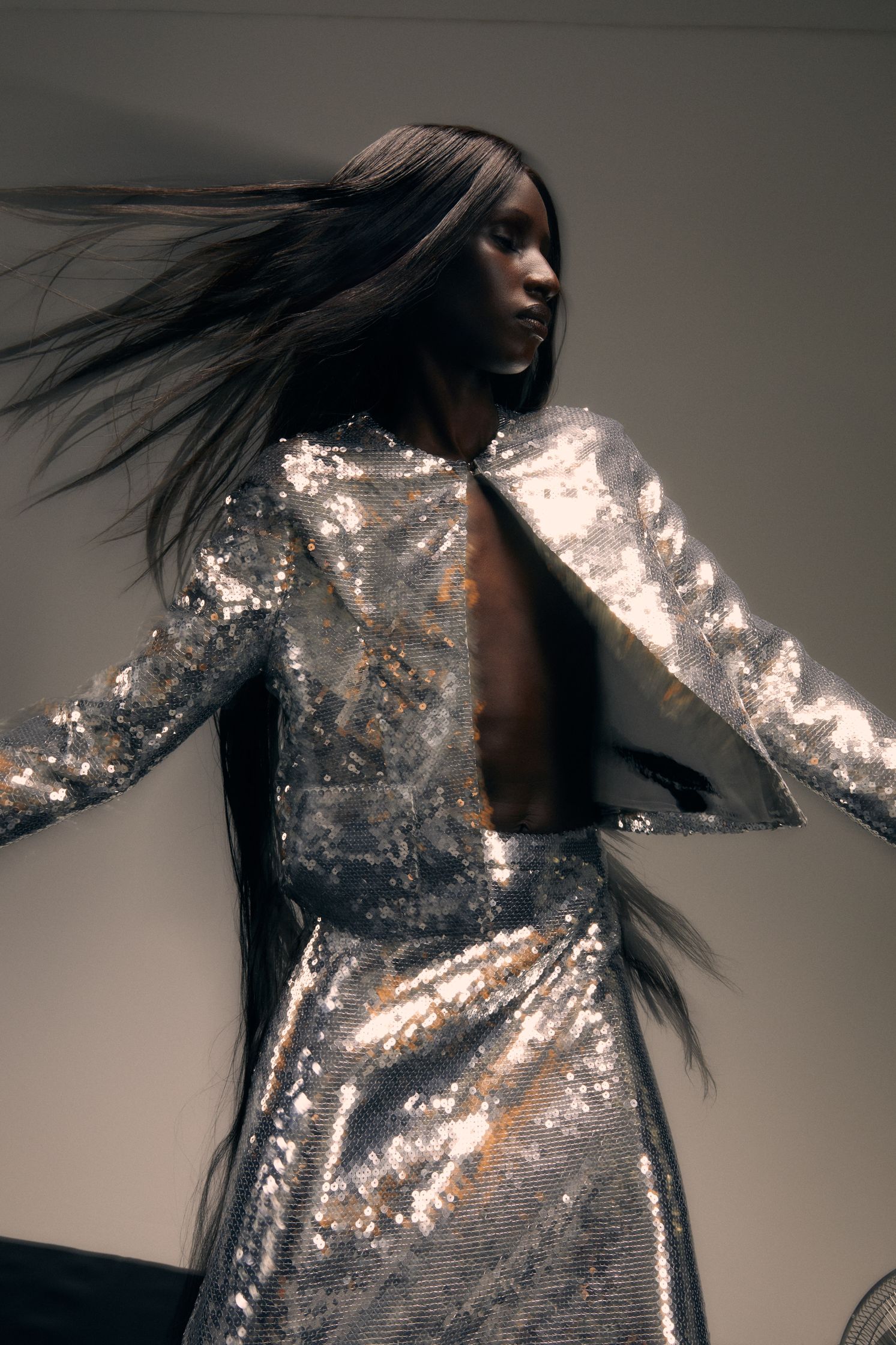 a woman in a silver dress with long hair