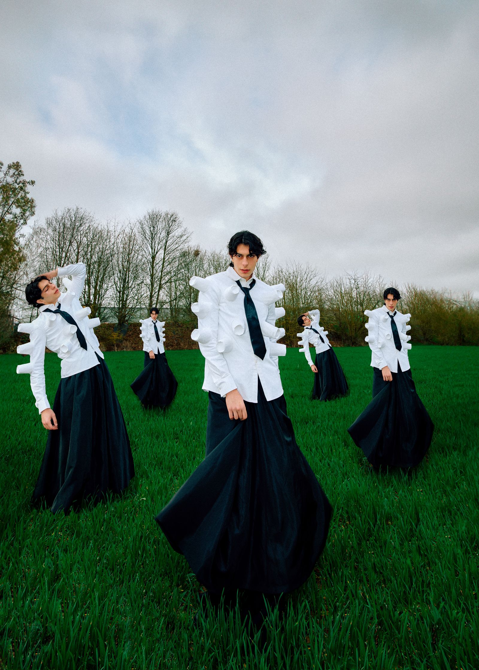 a group of men in white shirts and skirts in a field