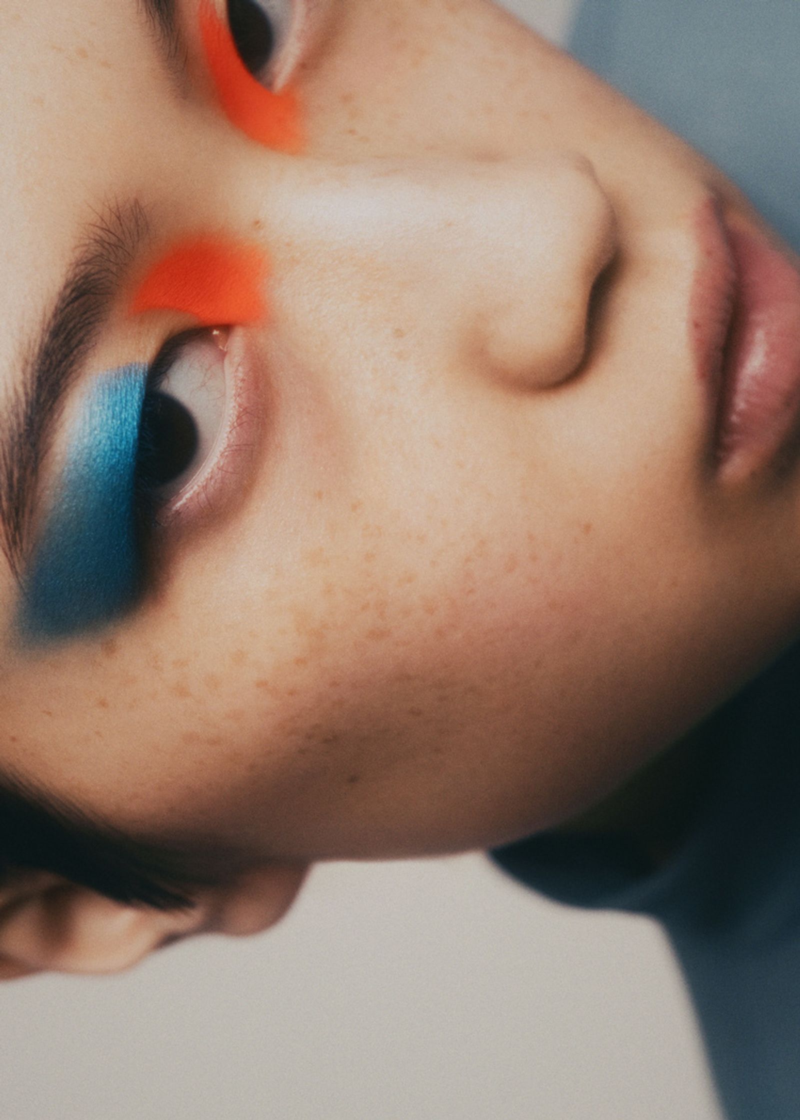 a woman with blue and orange eye makeup