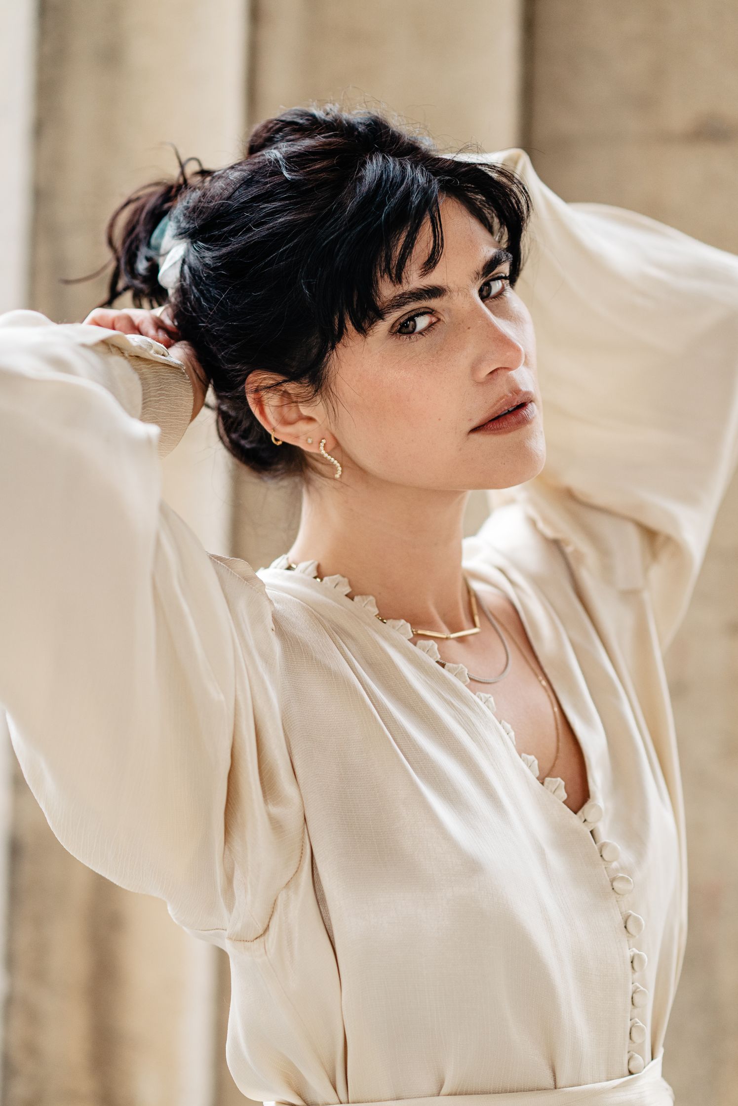 a model in a white dress posing for a photo with maren jewellery