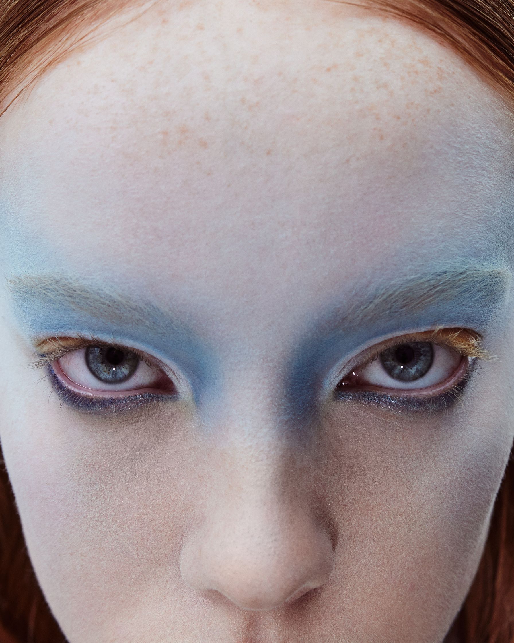a close up of a woman with blue makeup on her face
