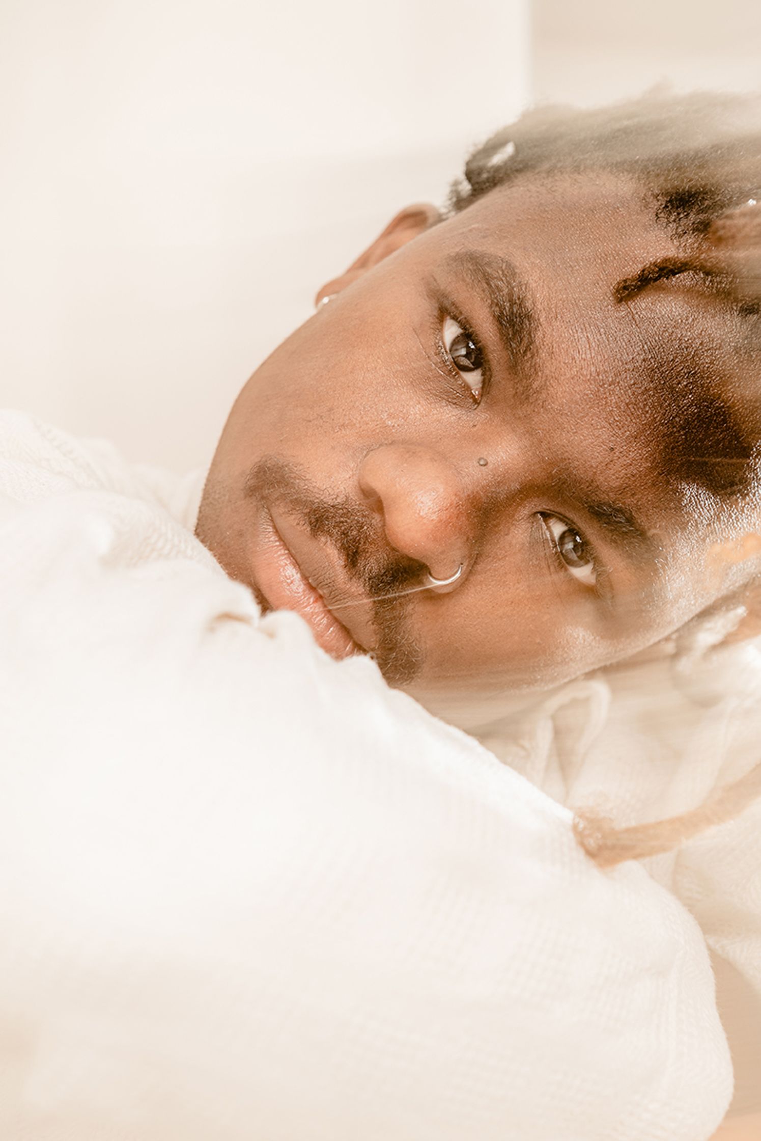 a blurry photo of man in a white shirt laying on a bed