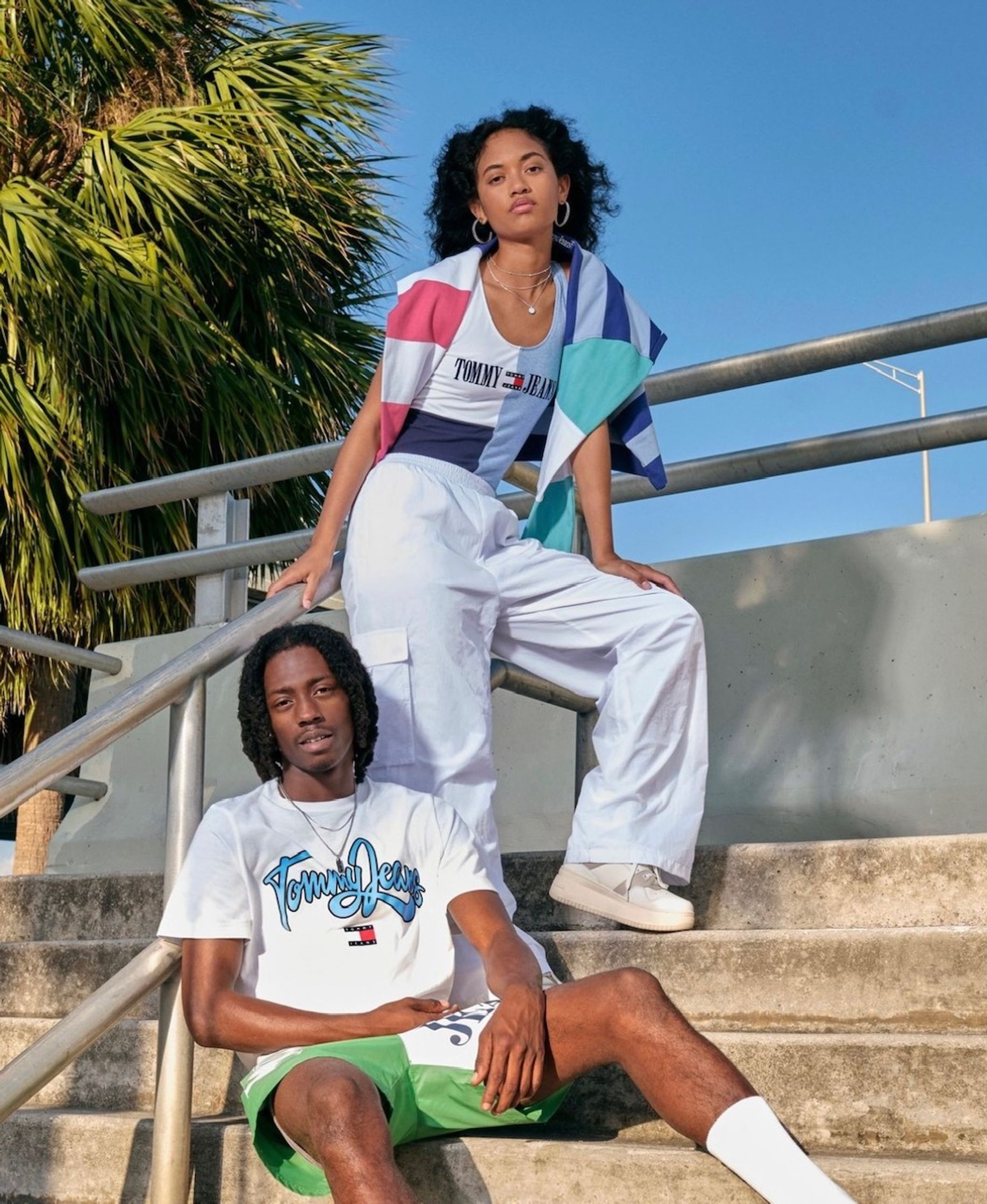 a man and woman posing on steps in front of a palm tree usc  uk