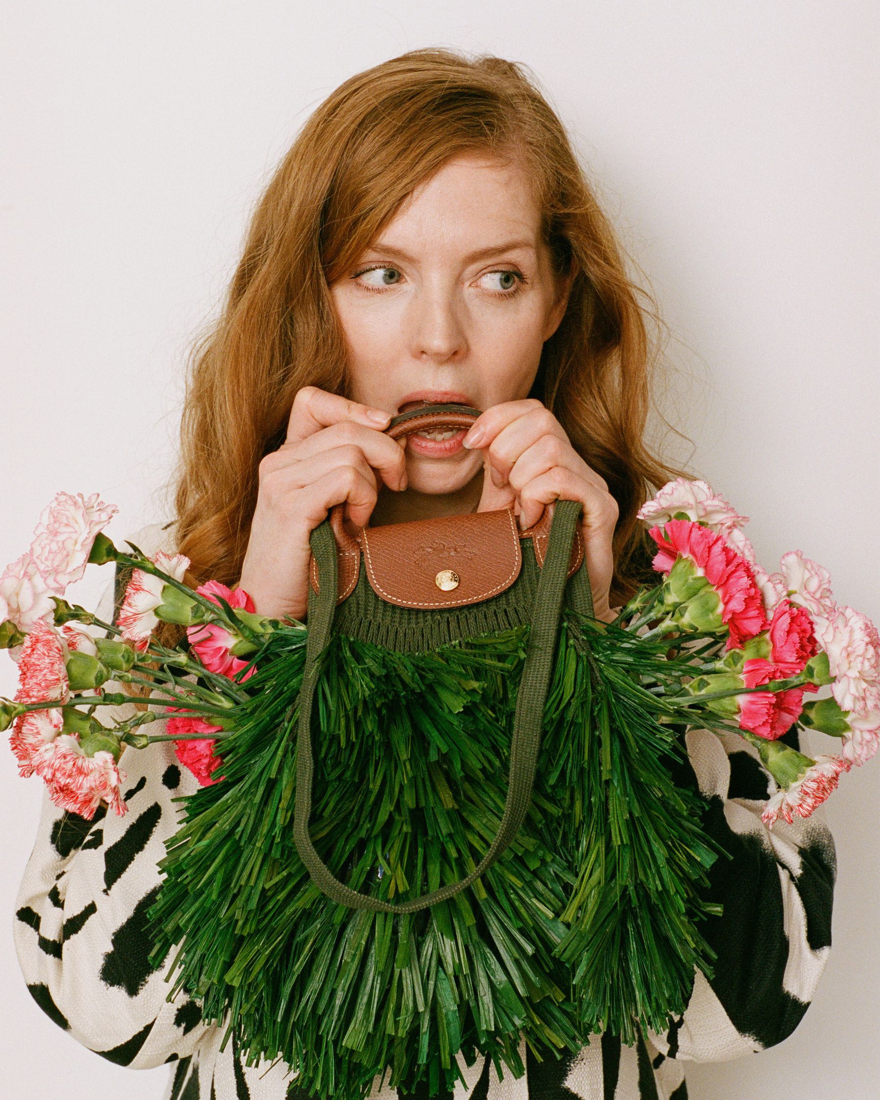Pheline Roggan holding a bag with flowers in it