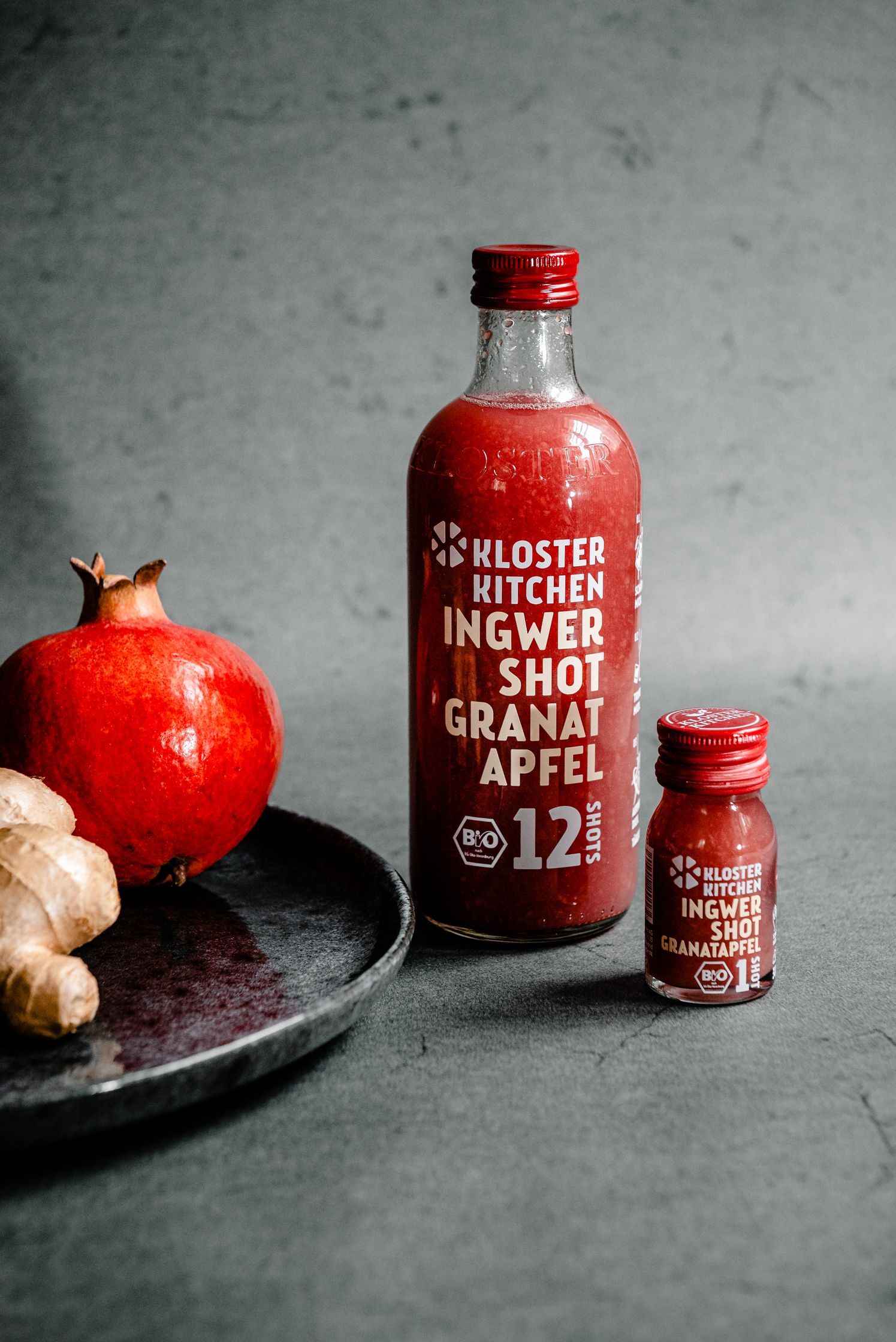 a klosterkitchen bottle of pomegranate juice next to a klosterkitchen bottle of ginger