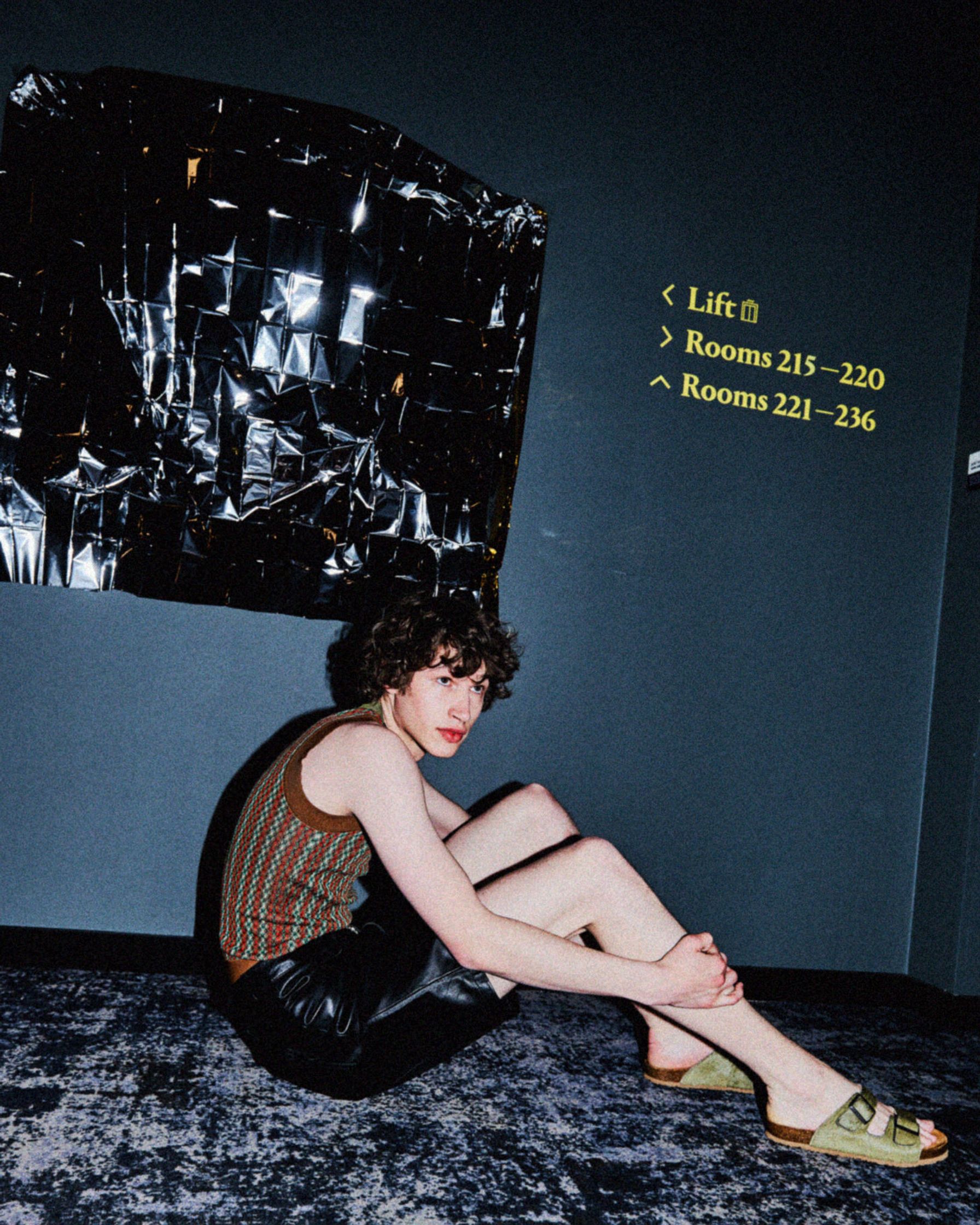 a woman sitting on the floor in front of a painting