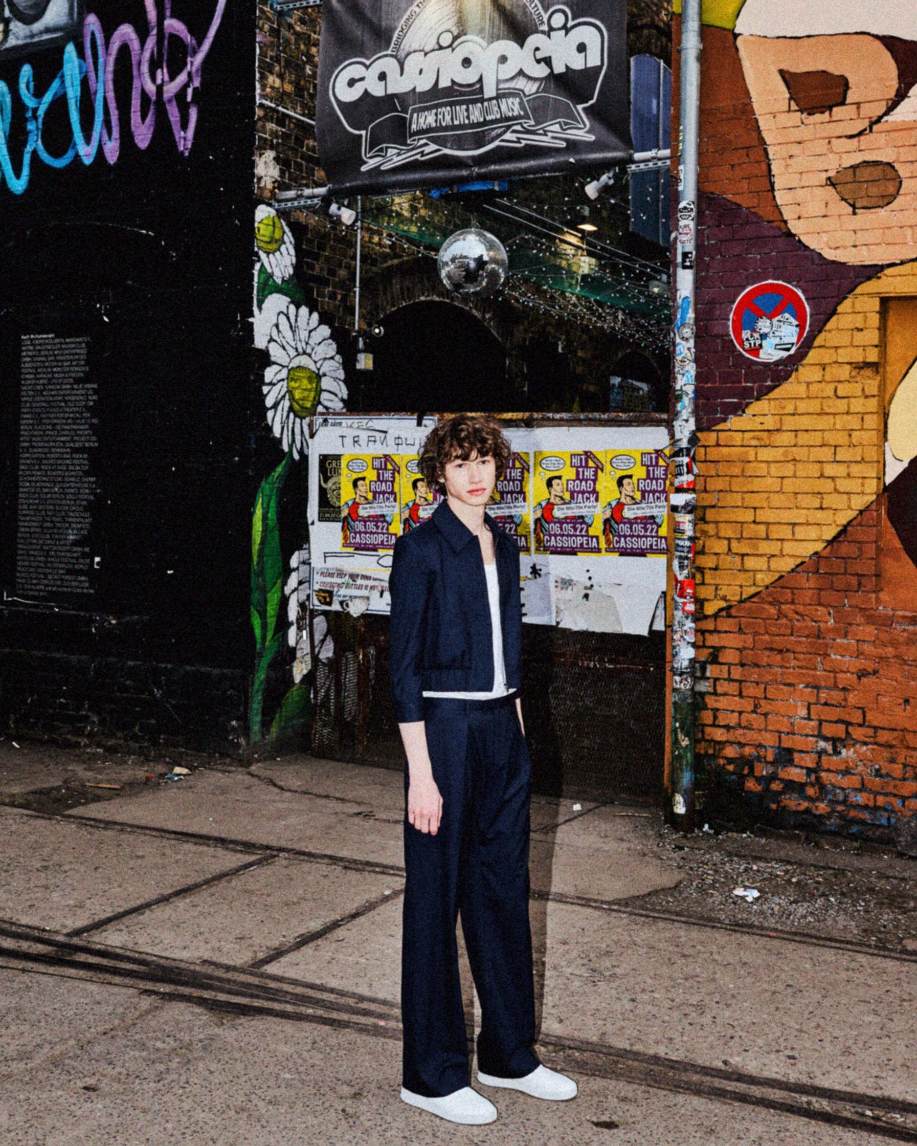 a man standing in front of a building with graffiti on it