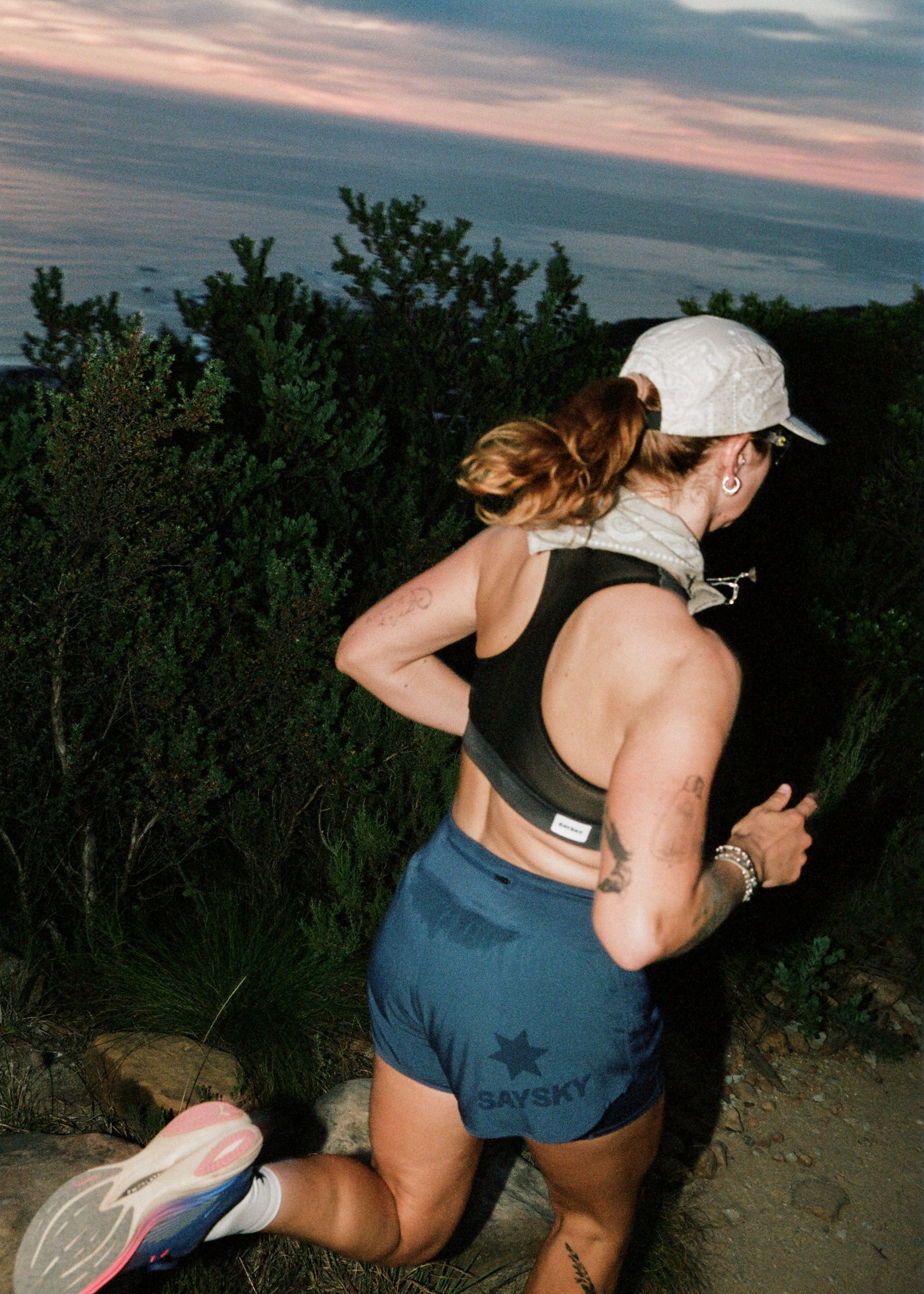 a woman running on a trail at dusk