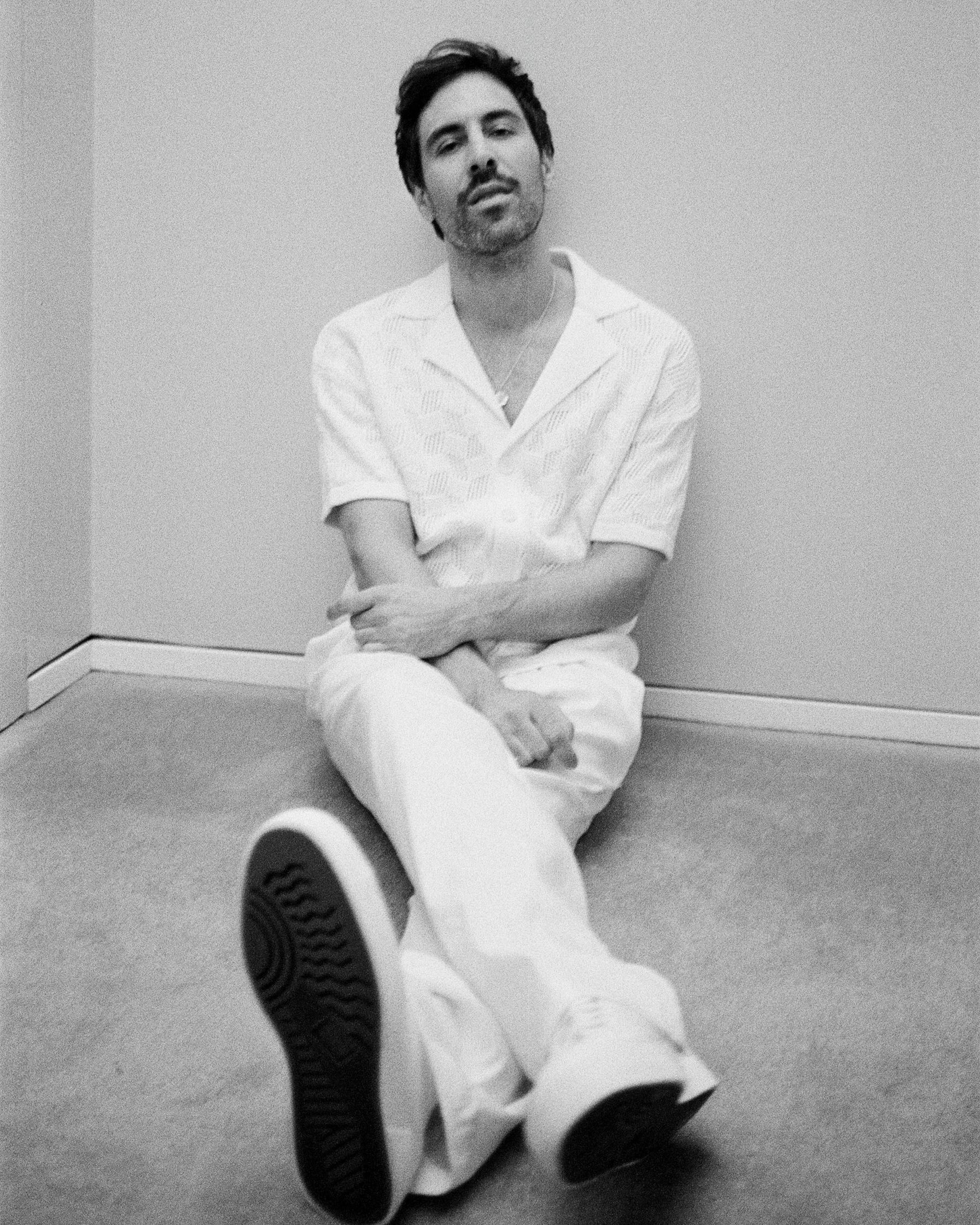 Max Giesinger sitting on the floor in a white shirt