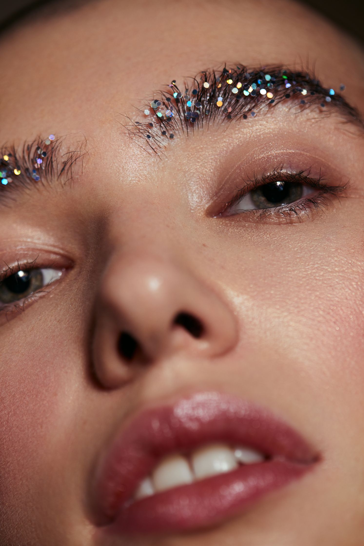 a close up of a woman with glitter on her eyebrows