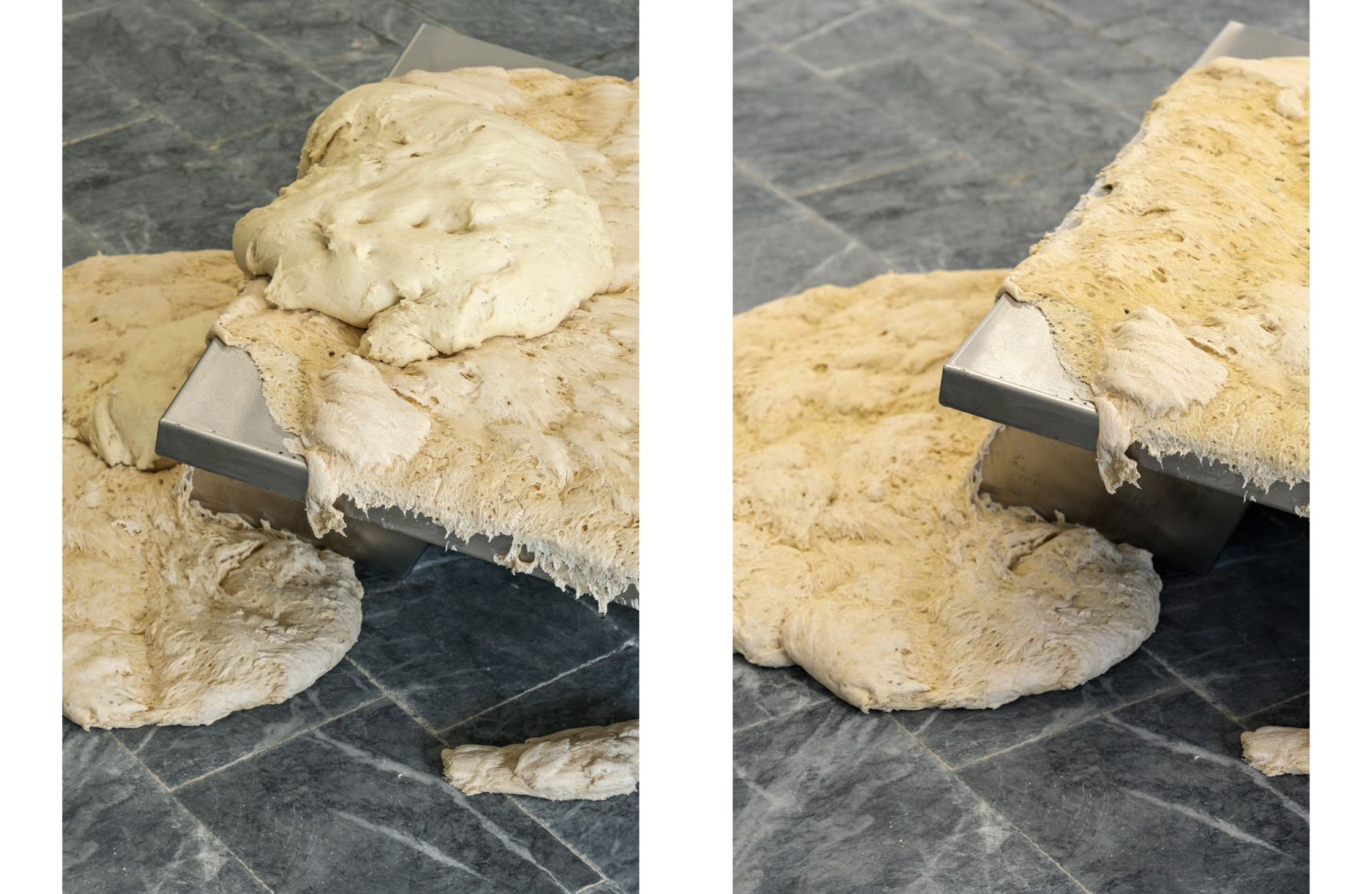 Bulging dough overflows and hangs from the edges of a metal table on a dark gray tiled floor.