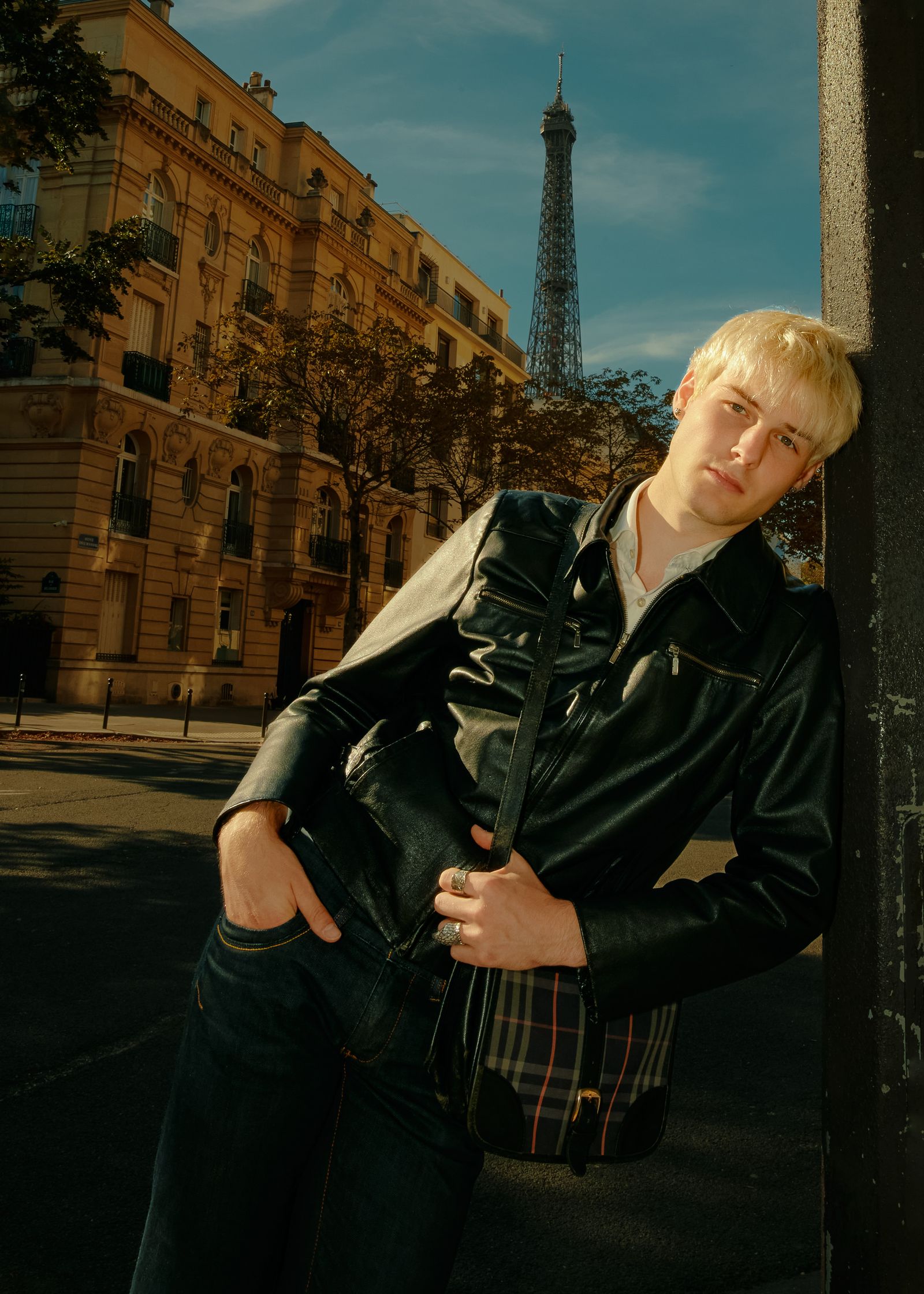 a man leaning against a pole