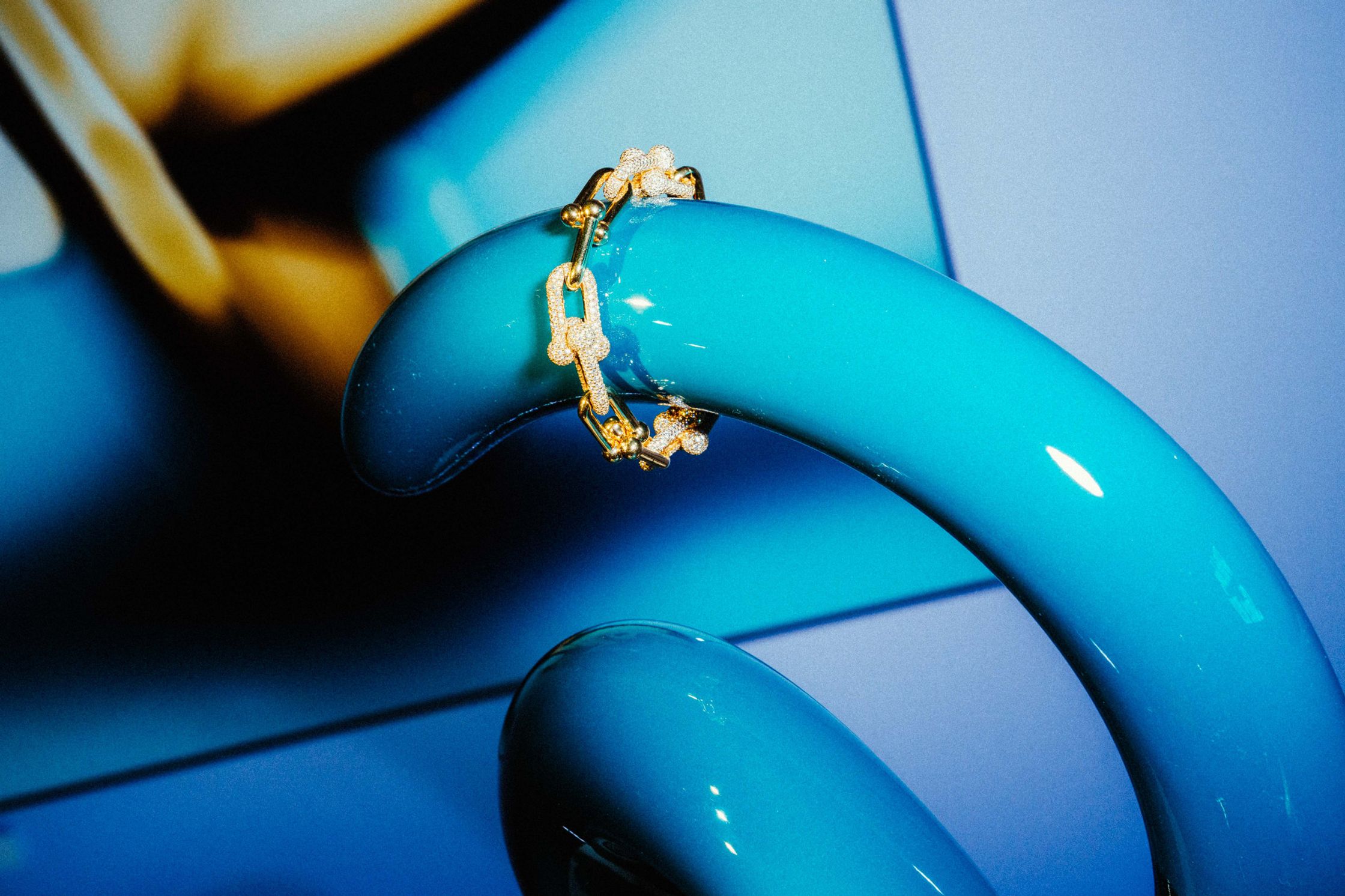 Goldenes Diamant-Kettenarmband drapiert über einem türkisblauen Tiffany-Objekt – Produktfotografie für Tiffany & Co. Berlin Event