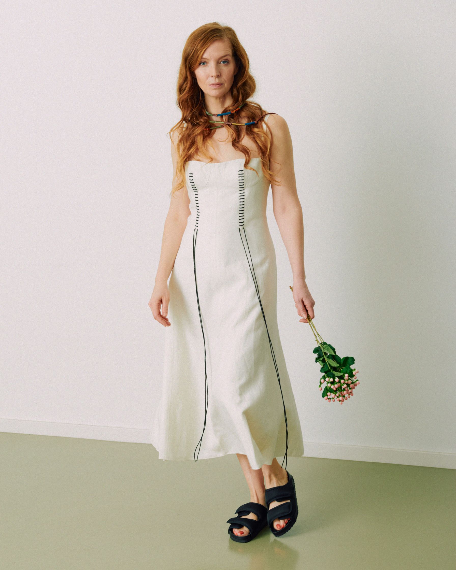 Pheline Roggan in a white dress holding a bouquet