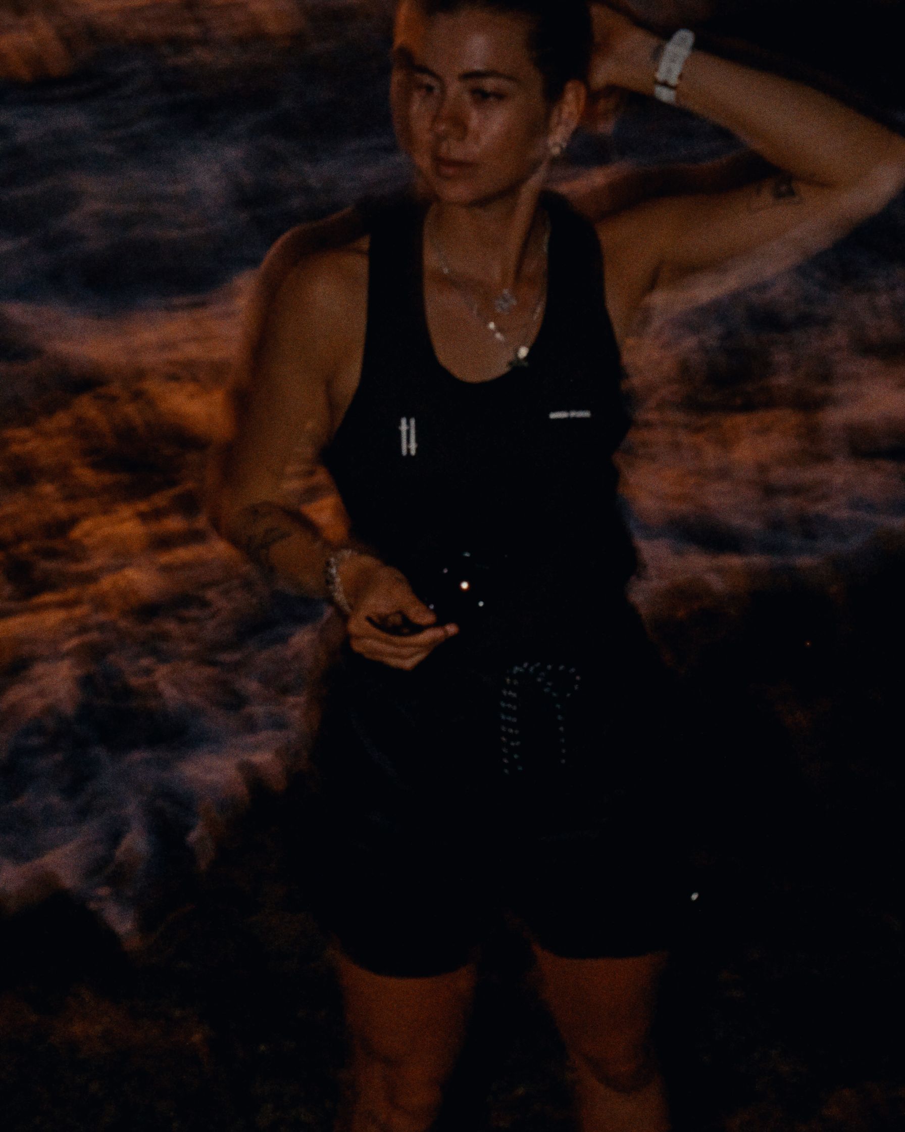 a woman standing on a beach at night