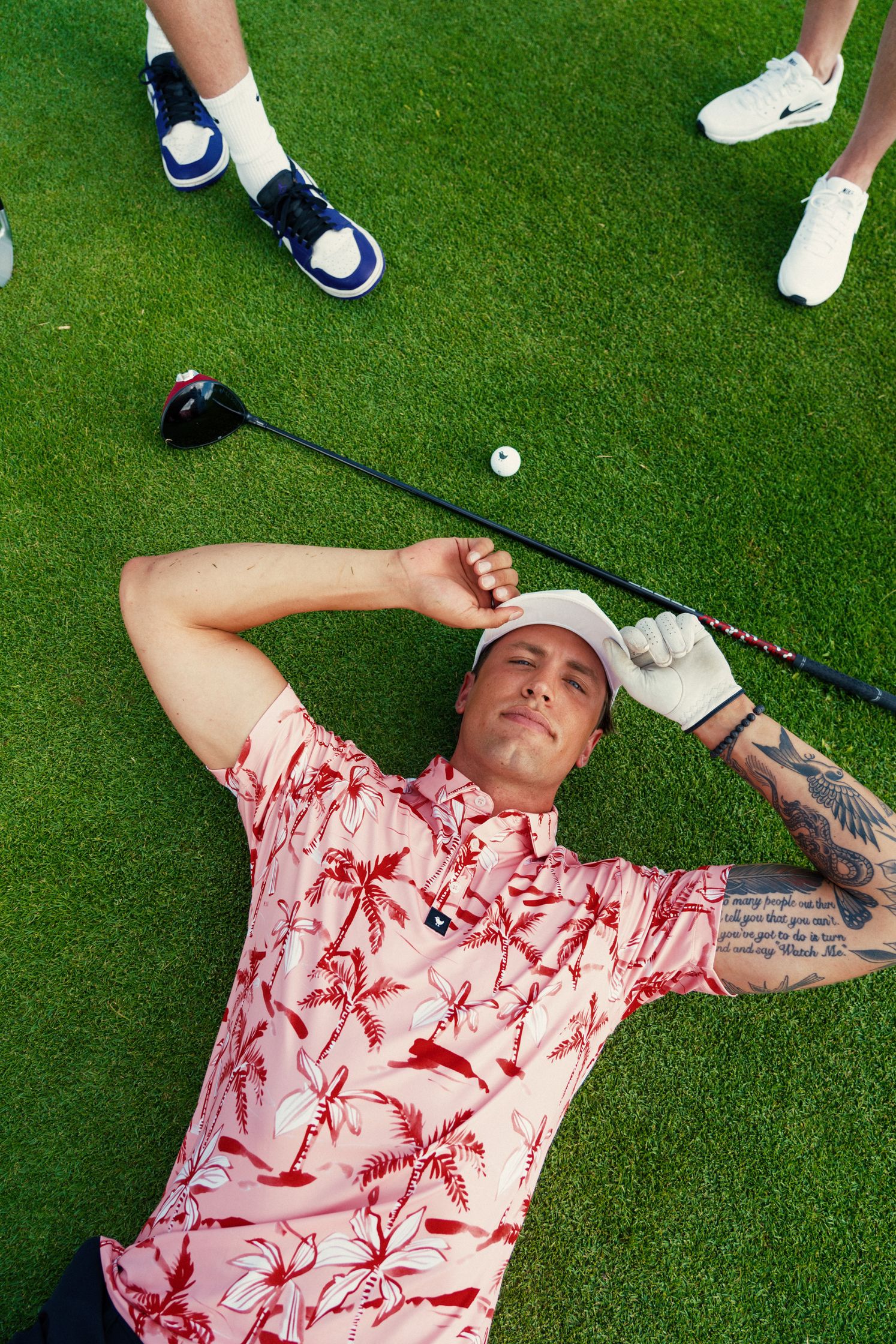 a man laying on the grass with a golf club
