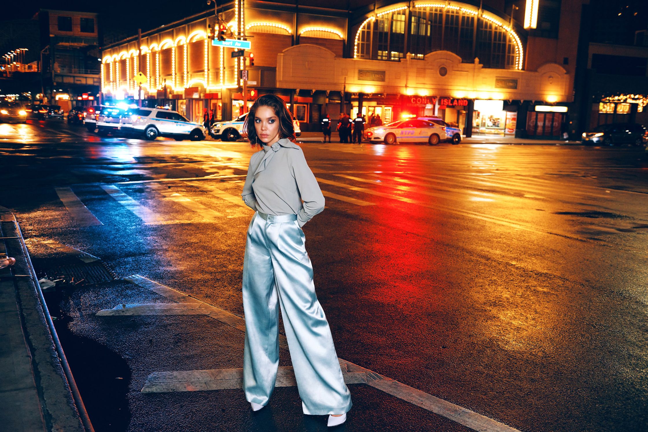 a woman is standing on a street at night