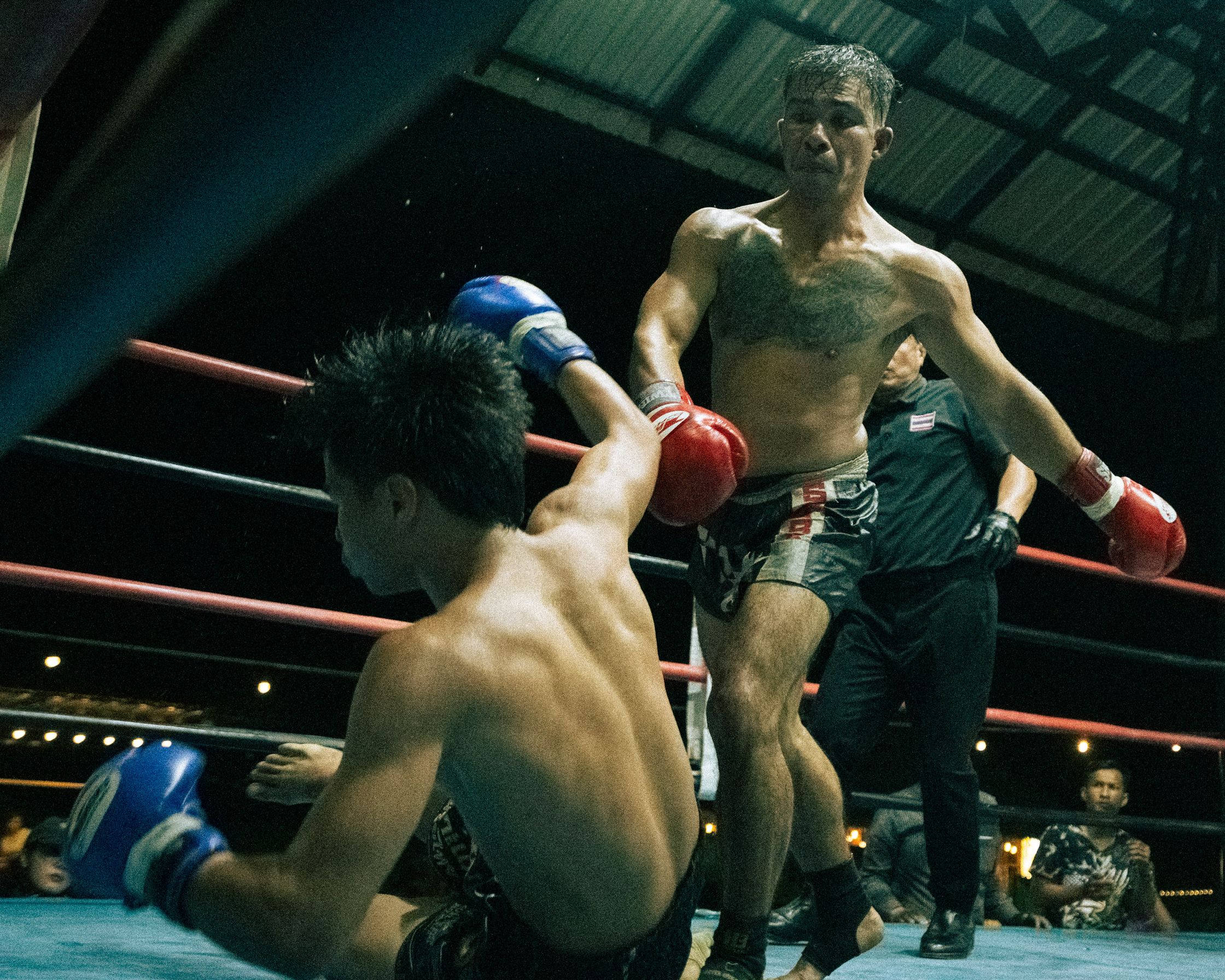 The decisive blow: A Muay Thai fighter landing a powerful punch that knocks down his opponent.