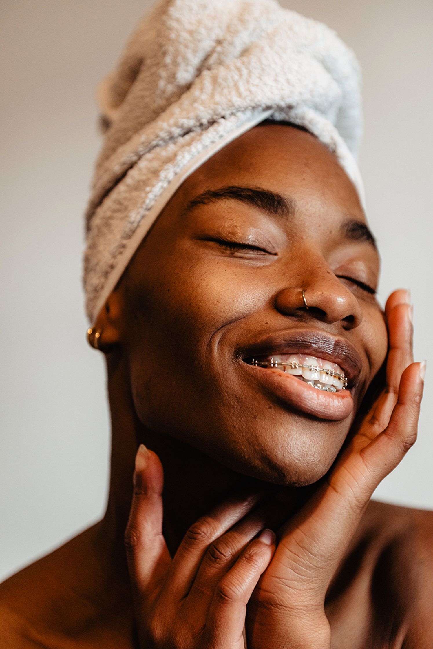 a black woman with a towel on her head after having a shower with everdrop products
