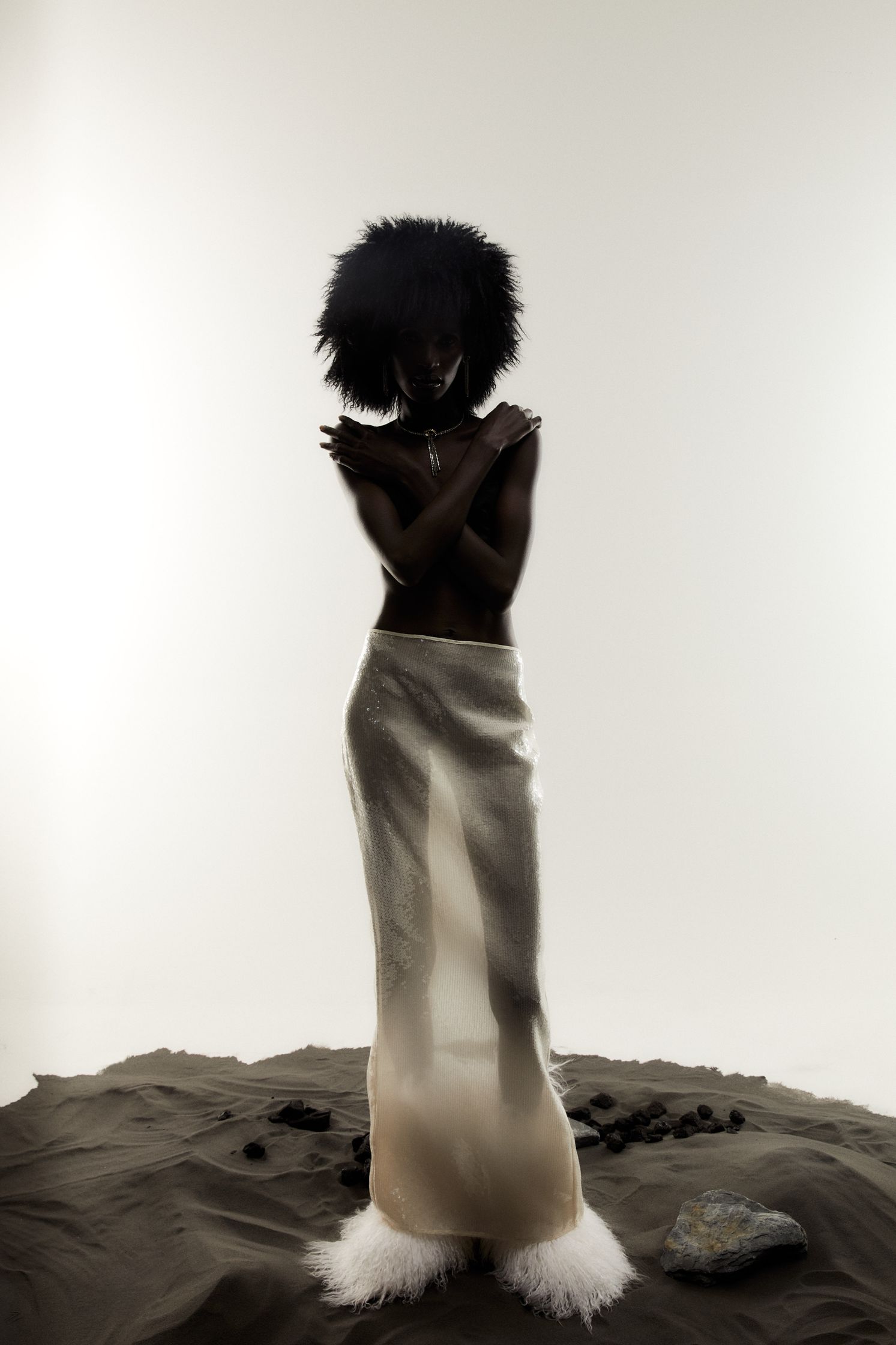 a woman in a white dress standing in the sand