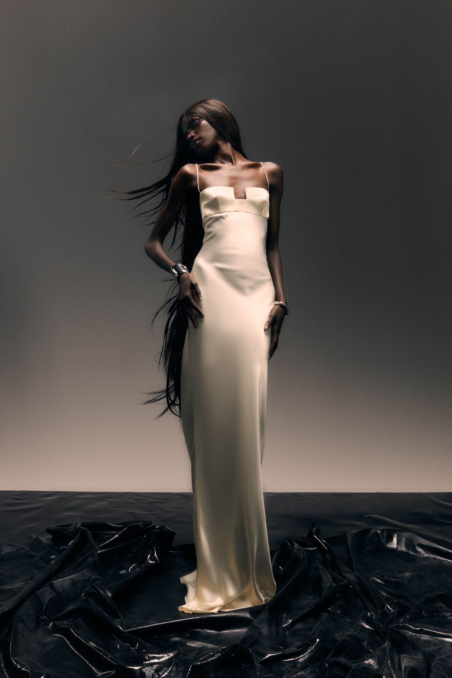 a woman in a white dress posing on a black background