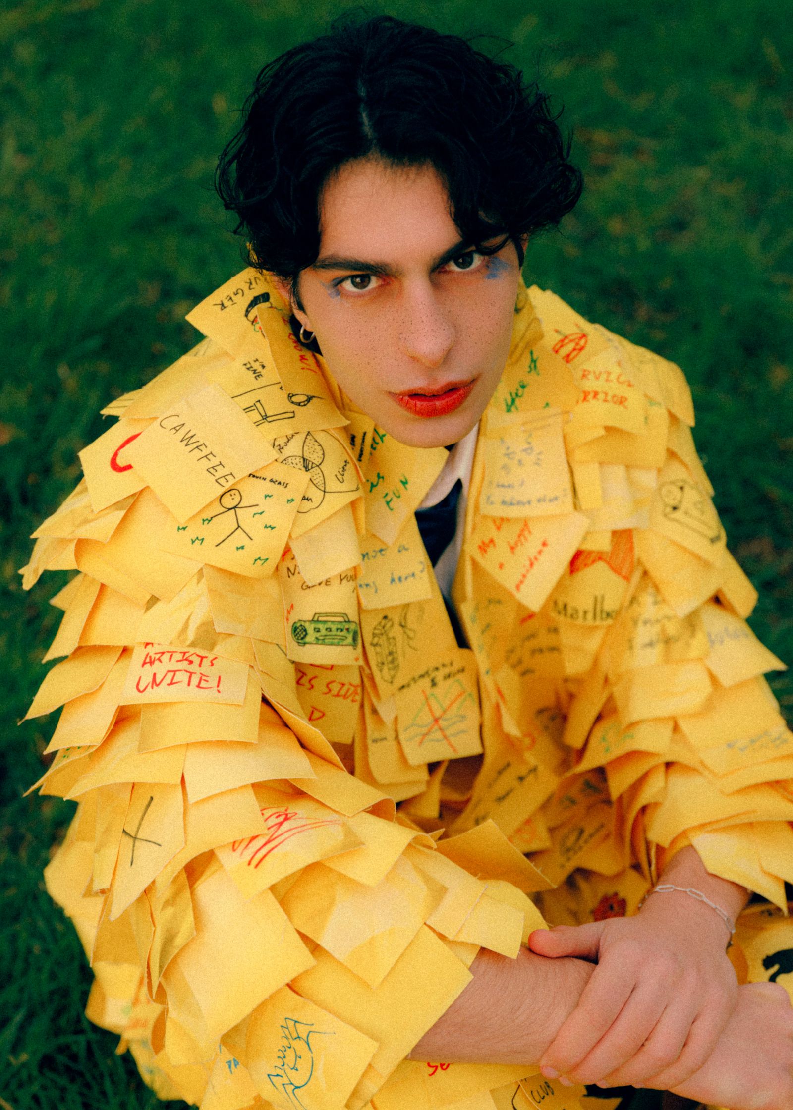 a man wearing a yellow jacket covered in post it notes inspired by office space brought to life by Zikun Zhu and photographed by Faith Adu Afriyie