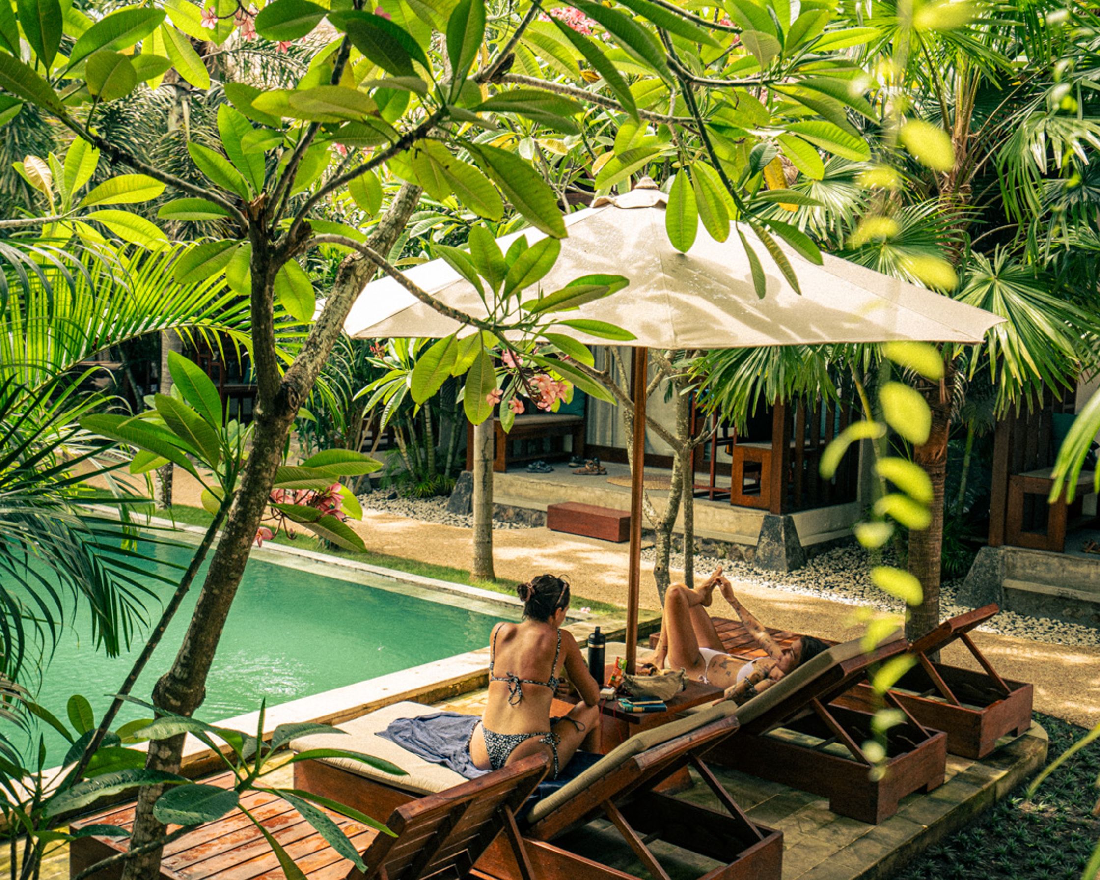 Two woman relaxing at the LMBK Sanctuary, in front of the swimming pool.